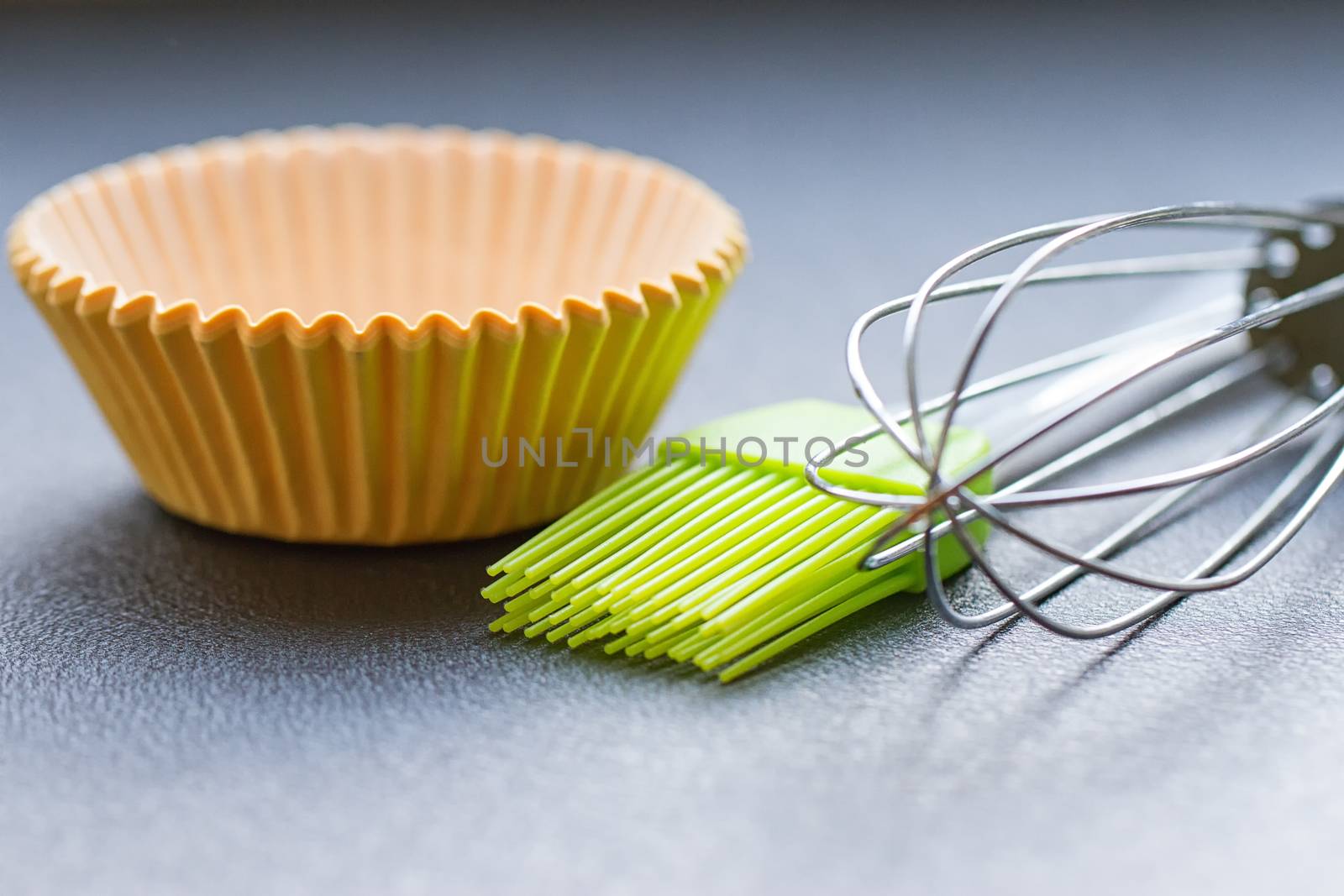 Rainbow silicone confectionery utensils on a blue background