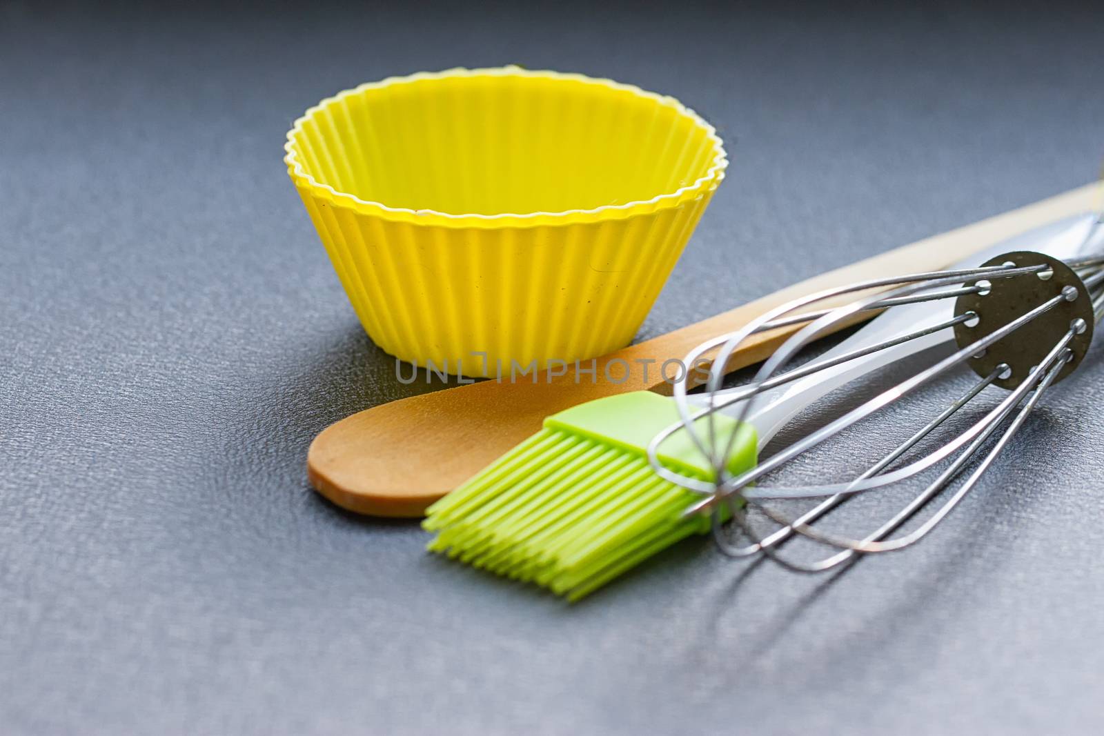 Rainbow silicone confectionery utensils on a blue background