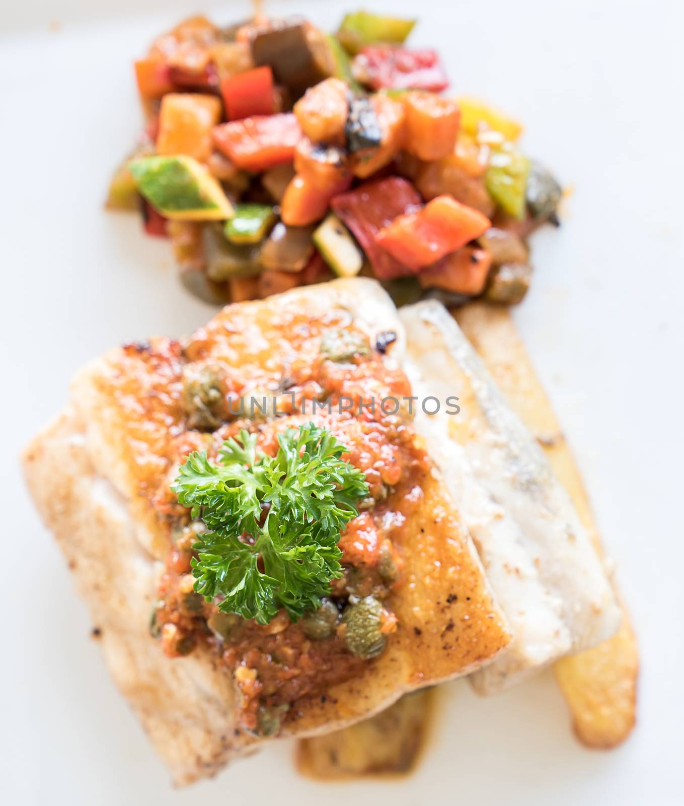 Grilled seabass fish with grilled vegetable on fries