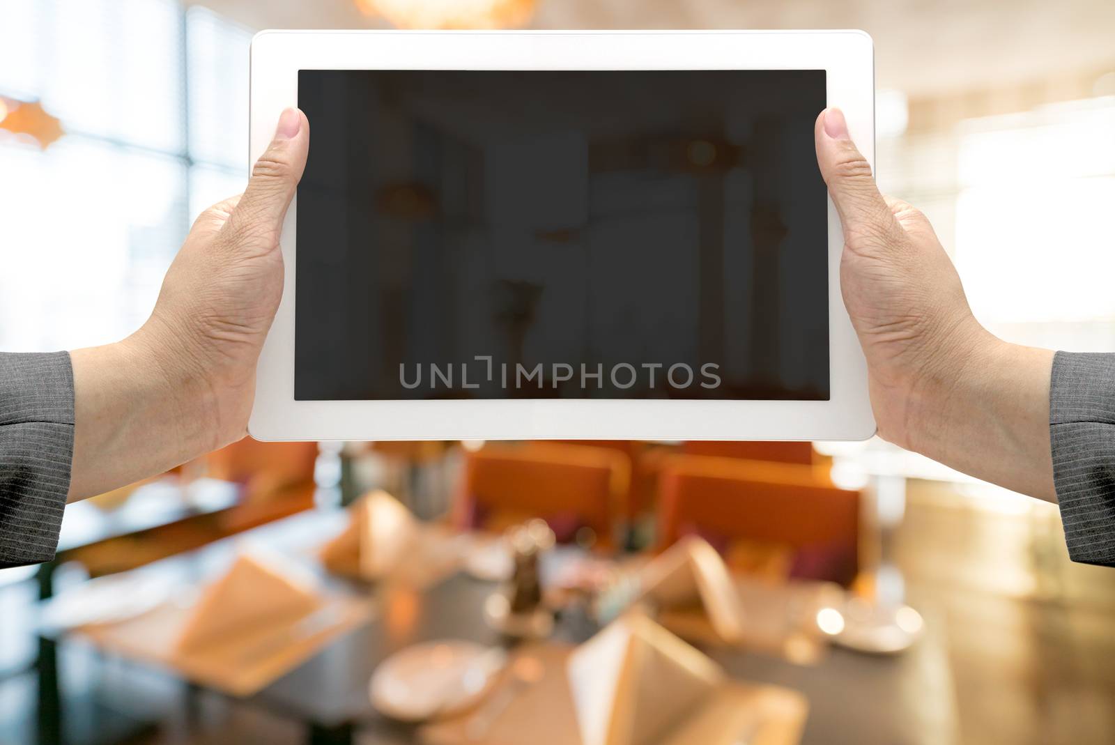 Abstrast Blurred background : restaurant cafe blur with bokeh with hand Hold digital tablet