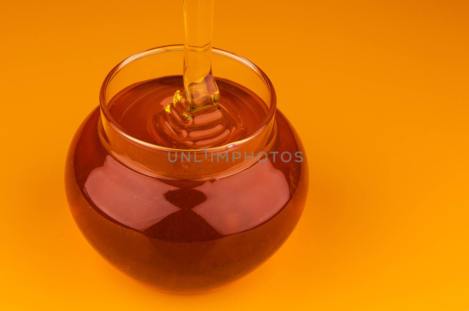 Pouring honey isolated on yellow background by xamtiw