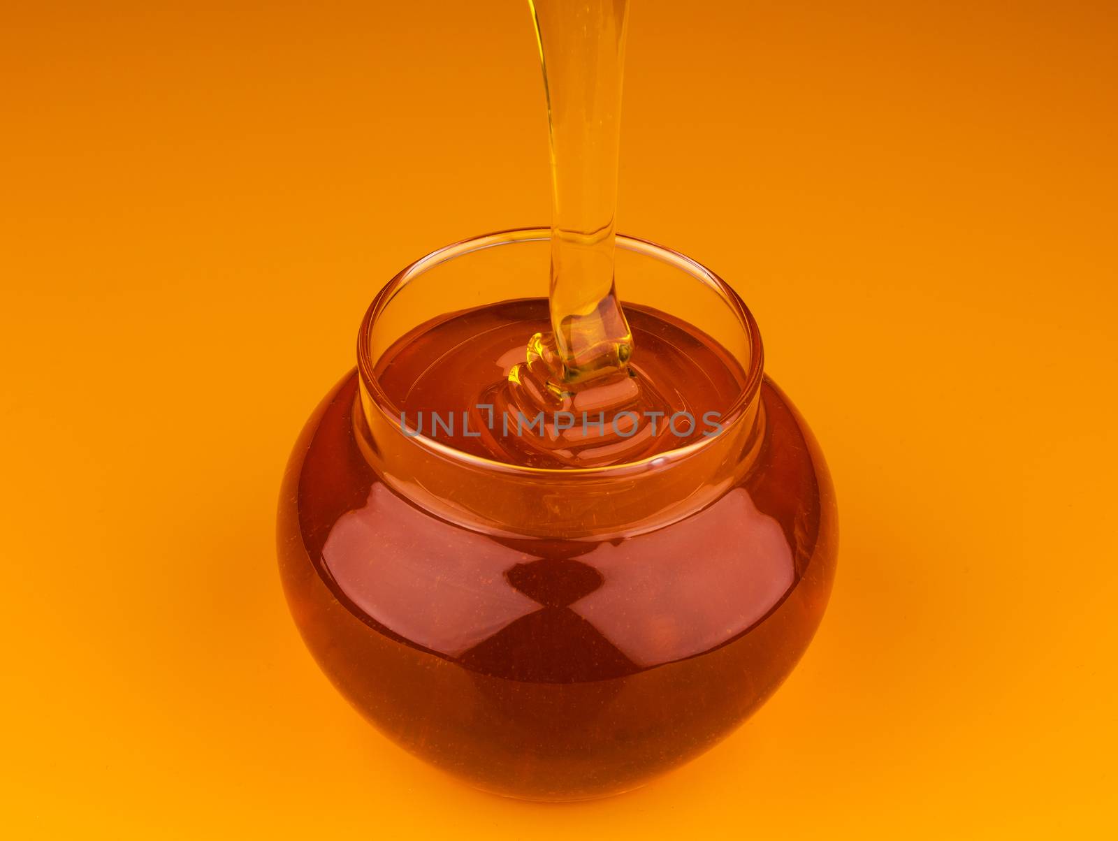 Pouring honey isolated on yellow background by xamtiw
