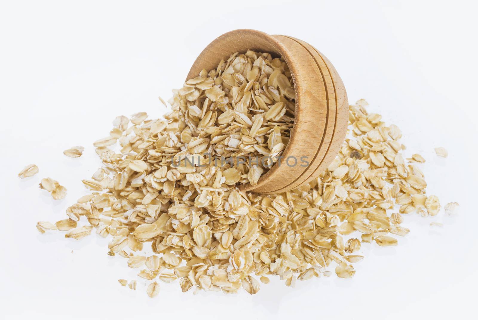 Isolated oatmeal. Oat flakes in wooden bowl on white background