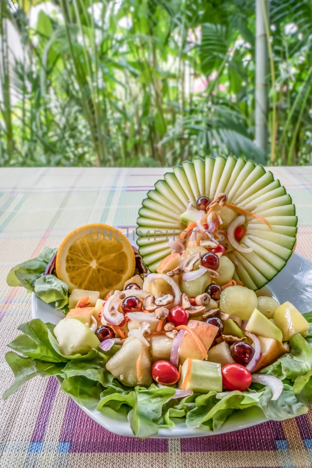 Colorful of fresh fruit salad in melon bowl with spicy sauce