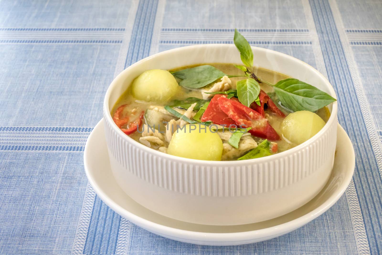 Green curry with chicken and mix vegetables in white bowl