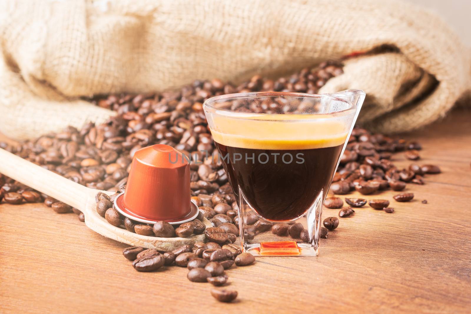 A cup of coffee roasted beans and capsule coffee by Robertobinetti70