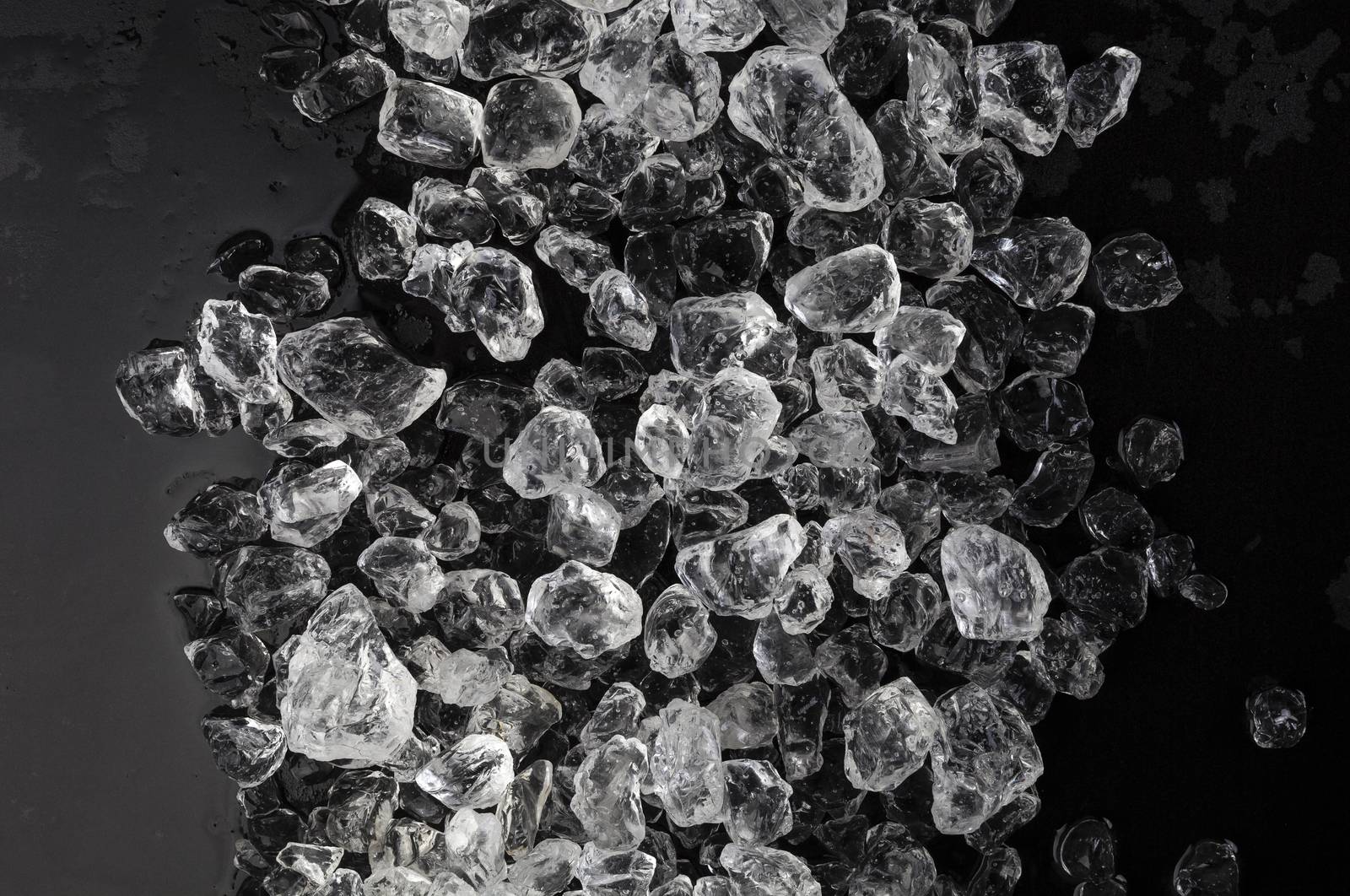 Pieces of crushed ice on black background by xamtiw