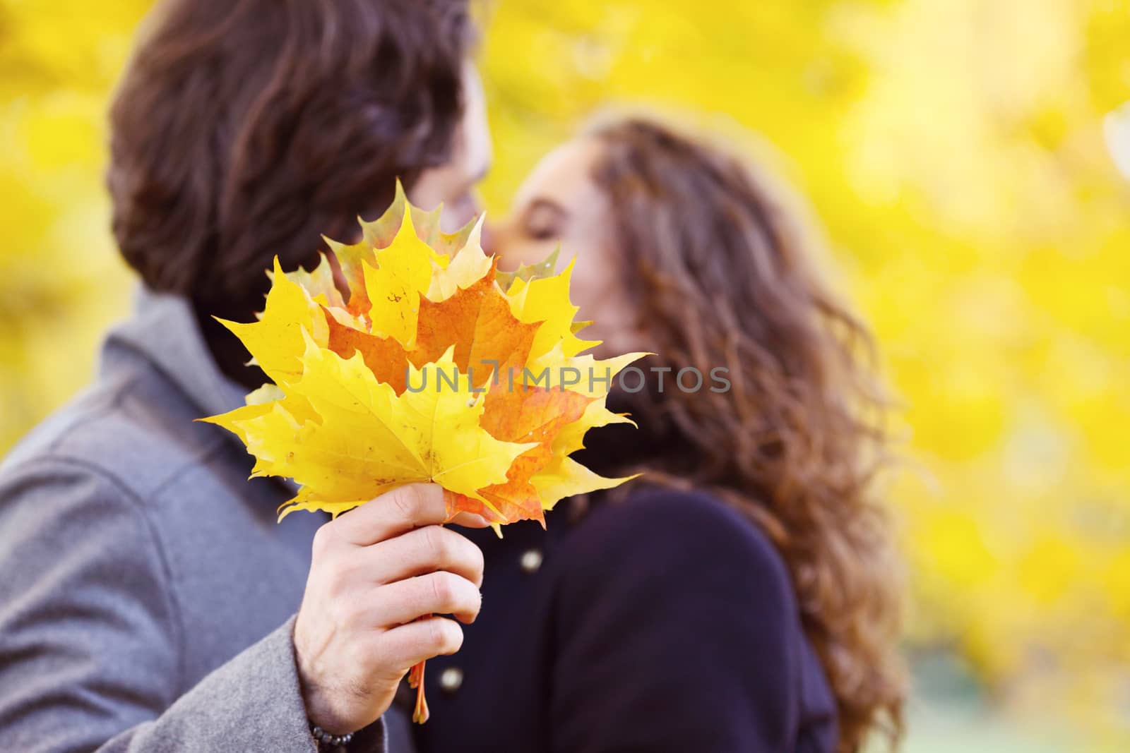 Love, relationship, family and people concept - couple kissing in autumn park