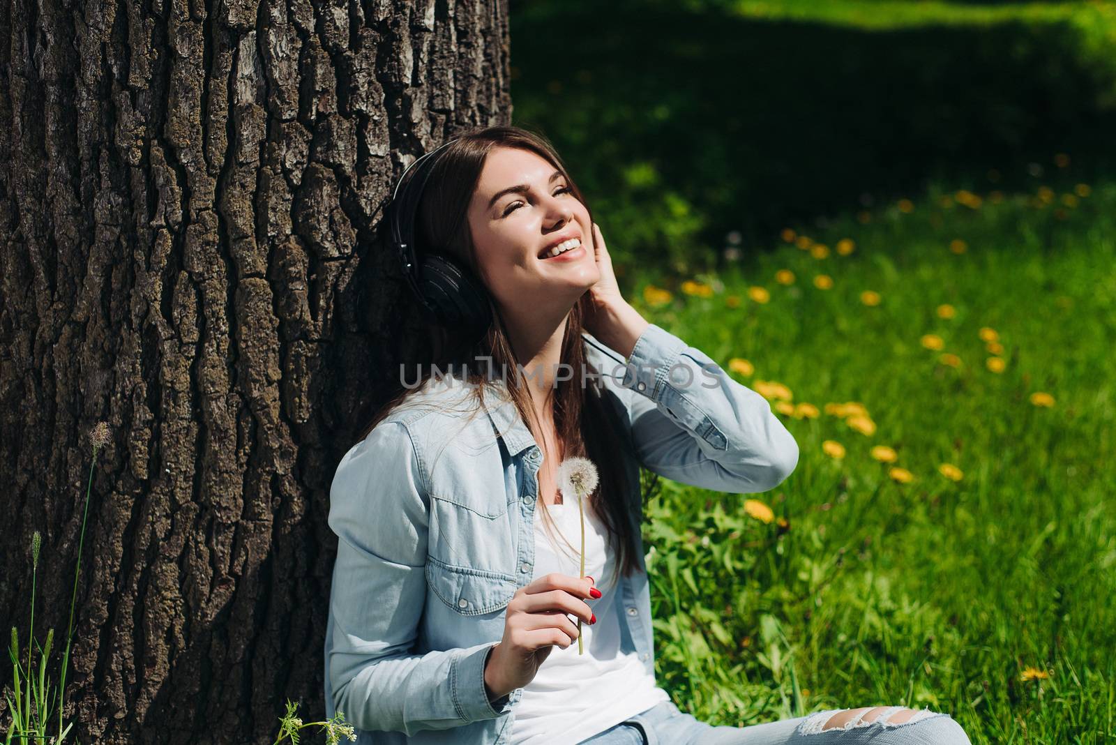 Woman with headphones in park by ALotOfPeople