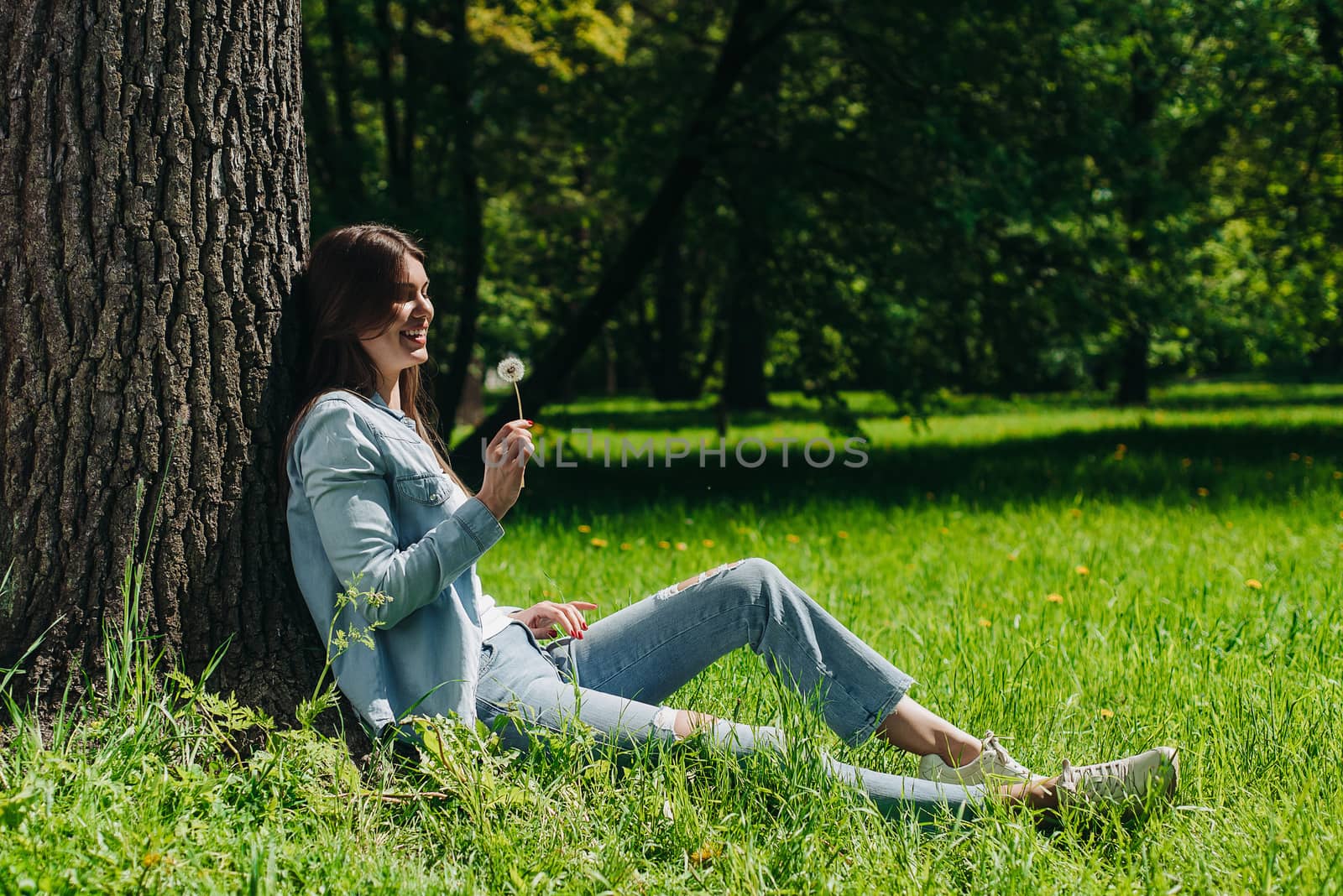 Woman with dandelion in park by ALotOfPeople