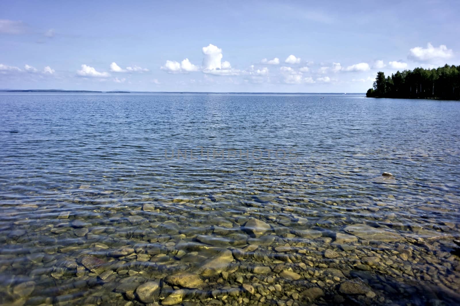 morning on the lake with clear water, you can see the rocky bottom