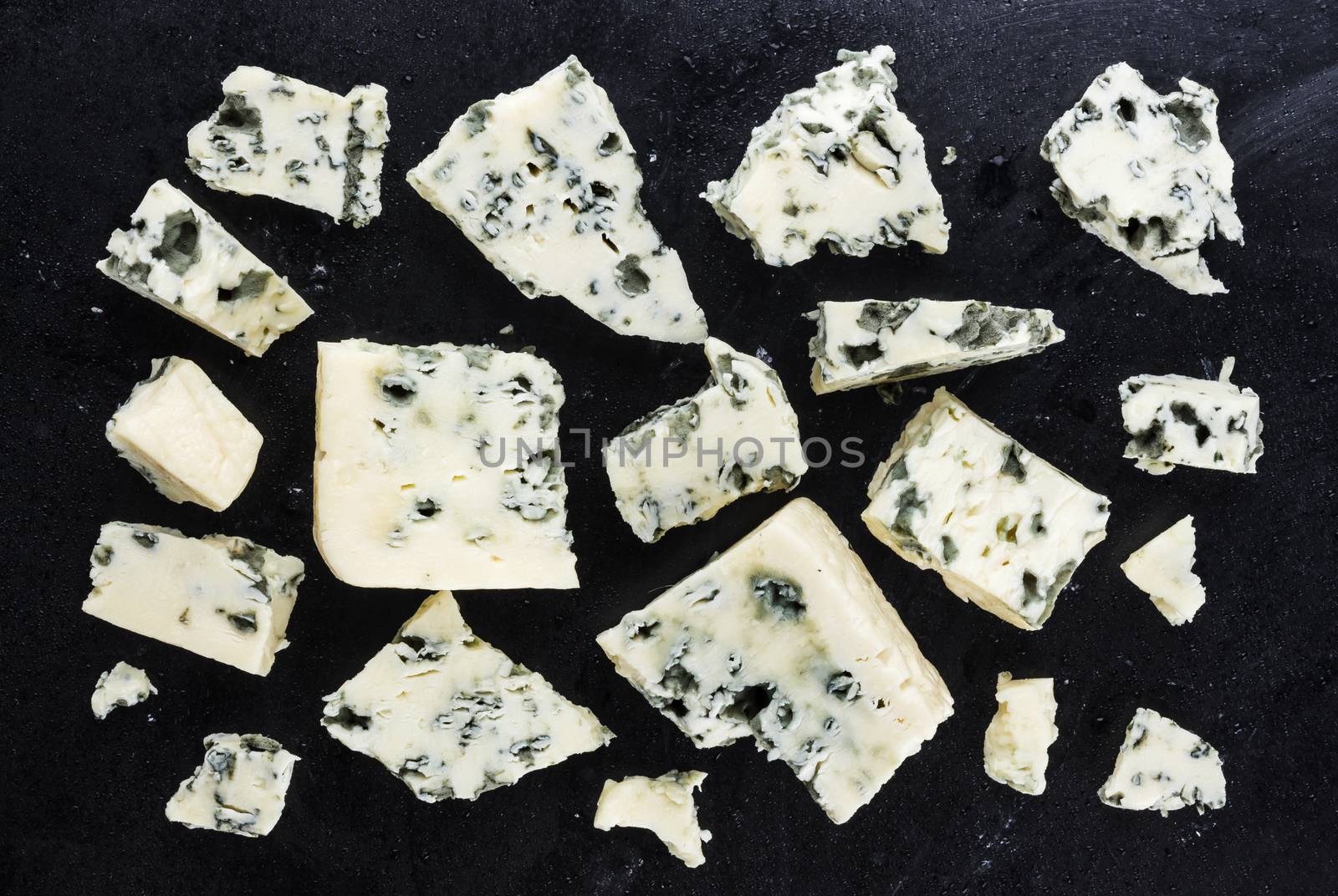 Pieces of danish blue cheese on dark background. Top view