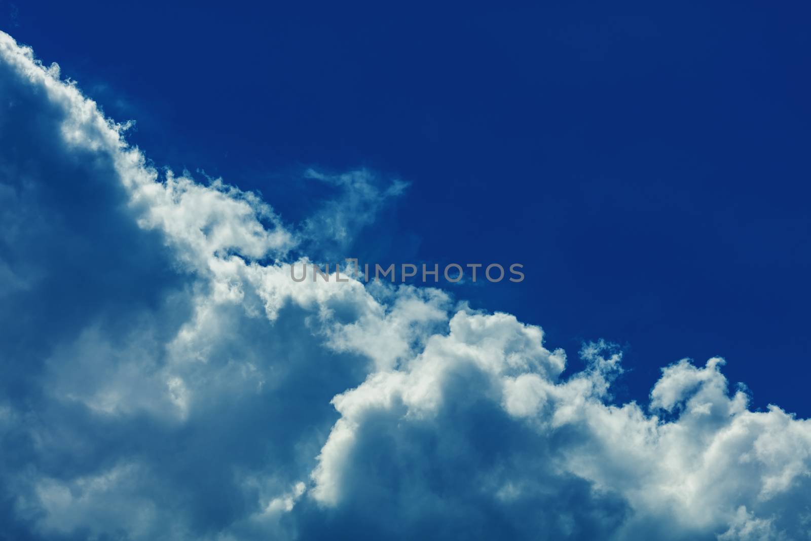 Deep blue bright sky with clouds background