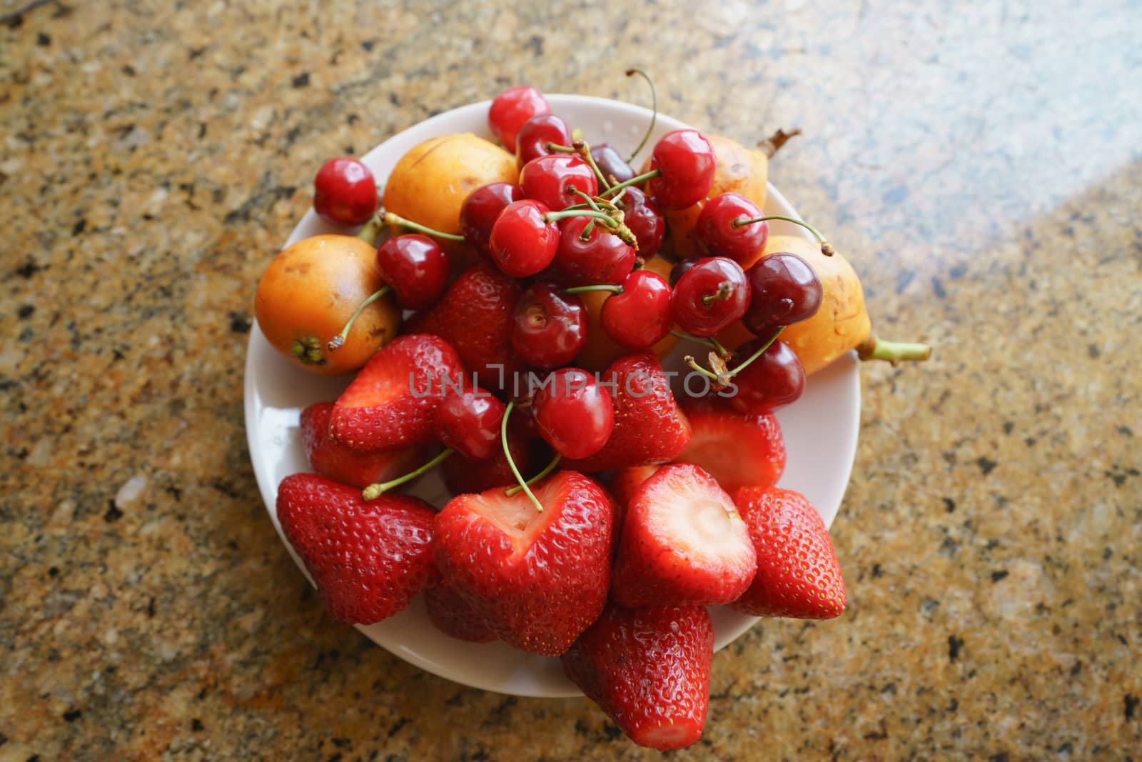 Juicy fresh ripe strawberries and wild cherries on a plate