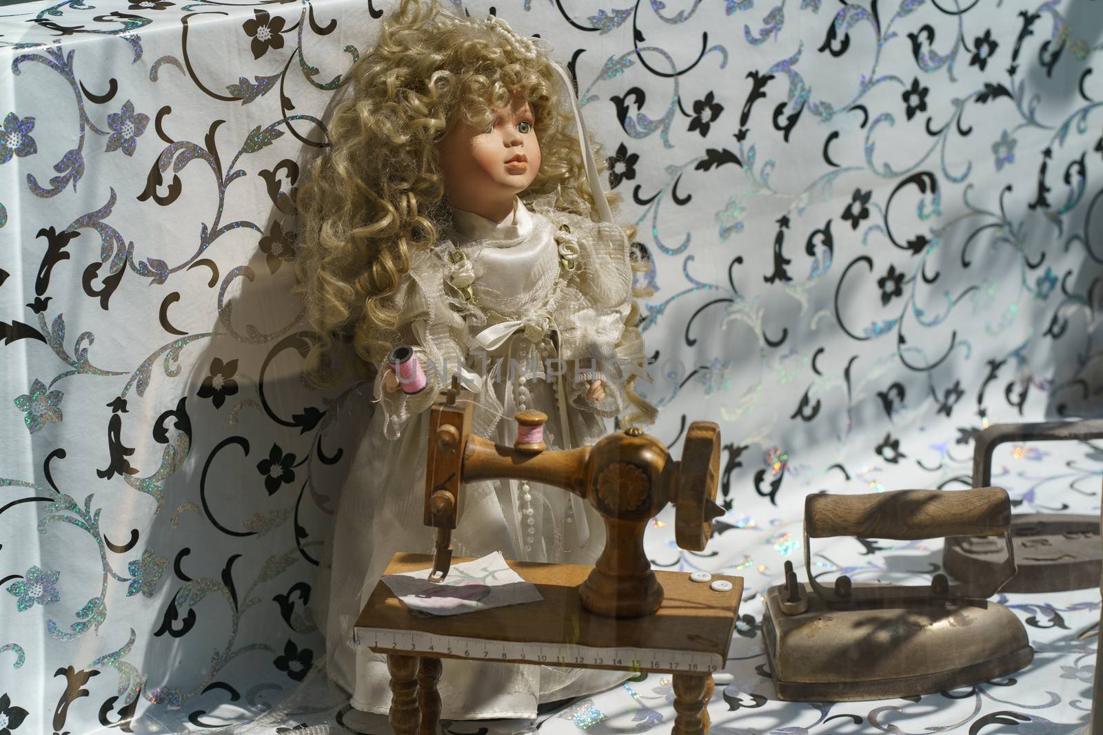 Image of old fashioned cute doll with iron and sewing machine