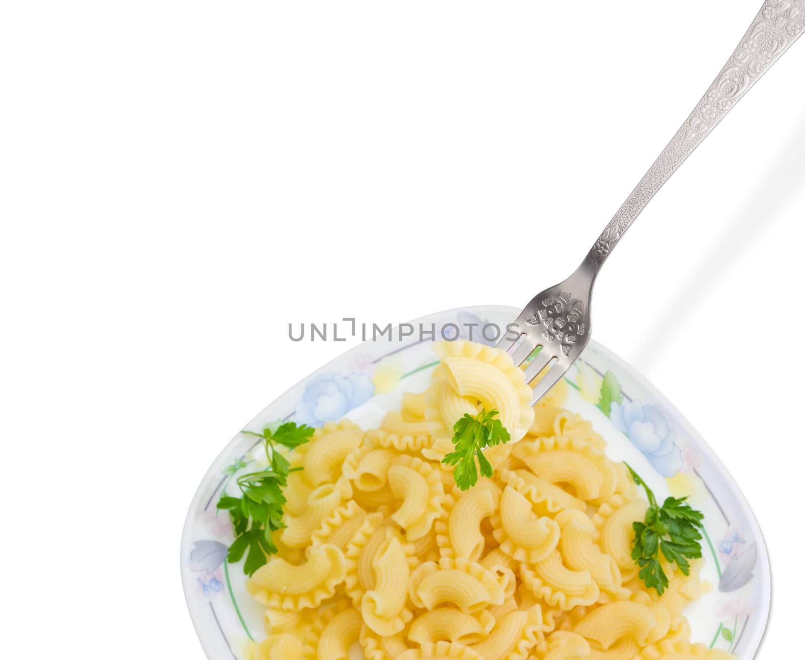 Fragment of the stainless steel fork with some cooked curved and ruffled pasta and the small parsley twig over of a dish with the same pasta on a light background
