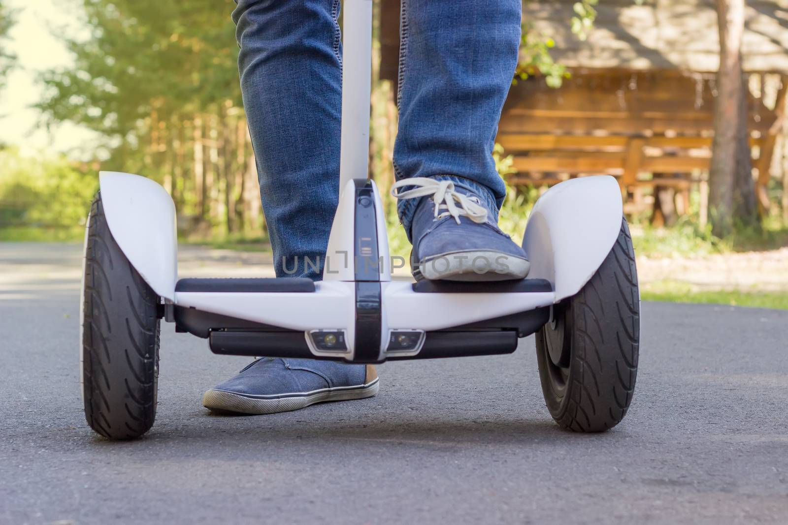 Legs of young man stepping on a self-balancing scooter