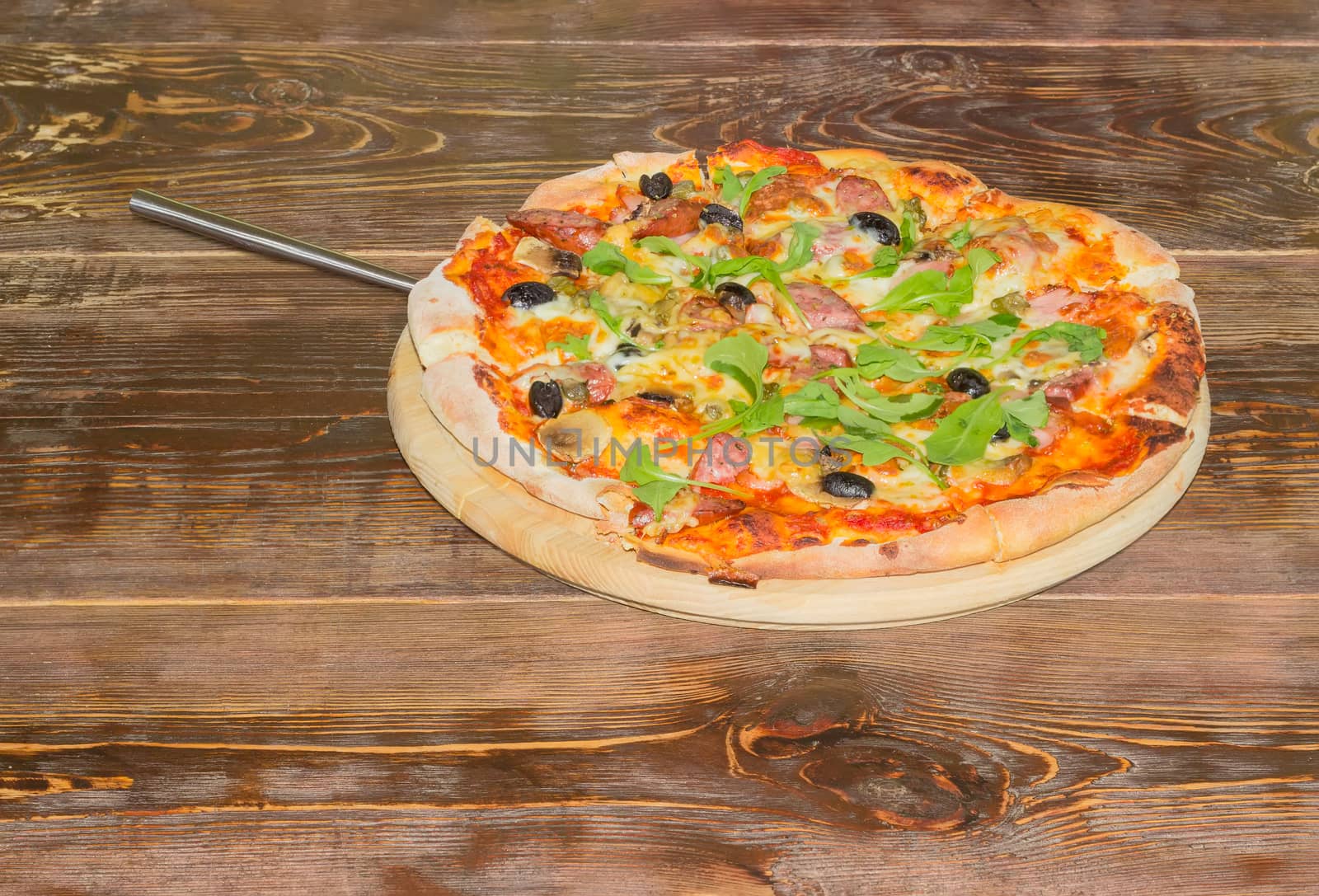 Pizza with pizza spatula on the old wooden table by anmbph