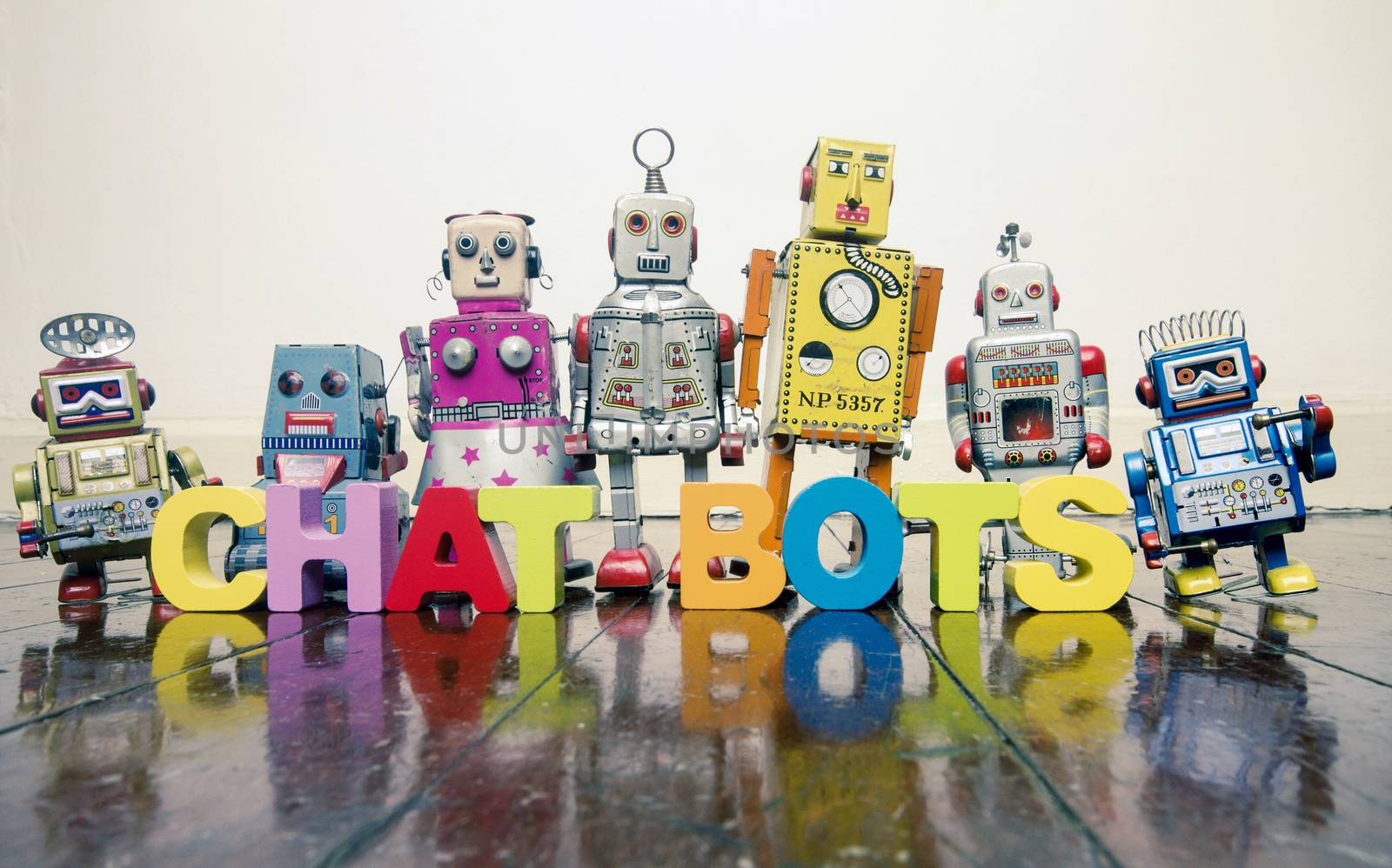 the word  CHAT BOTS  with wooden letters and retro toy robots  o by davincidig