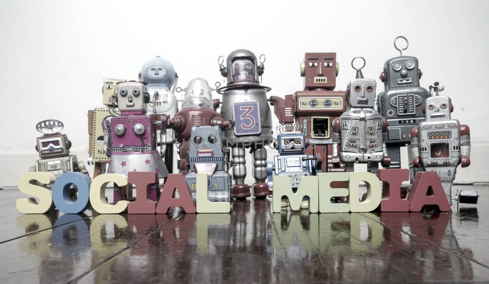 the words SOCIAL MEDIA   with retro robot toys on a wooden floor by davincidig