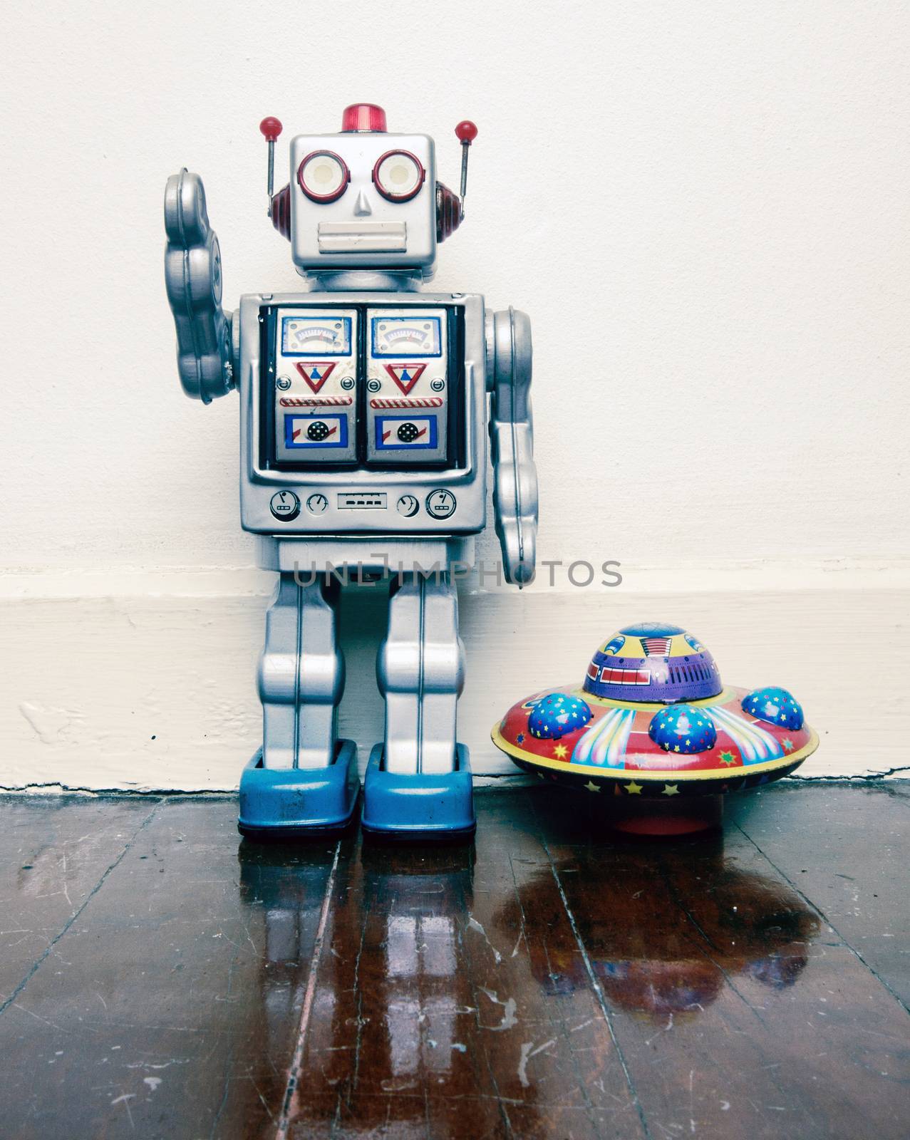 vintage robot toy  with a  toy UFO on a old wooden floor  by davincidig