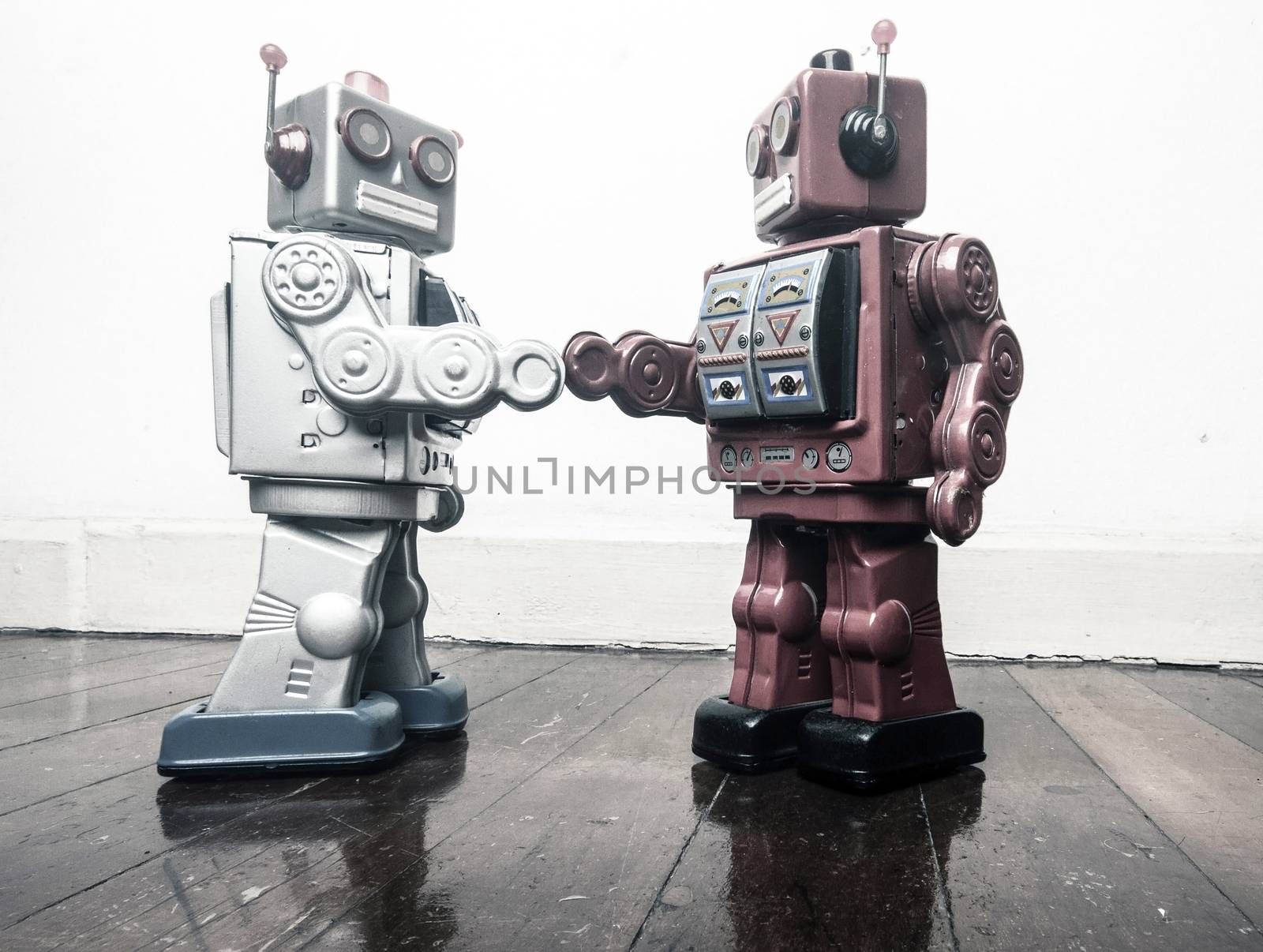 two vintage robot shake hands on a old wooden floor  by davincidig