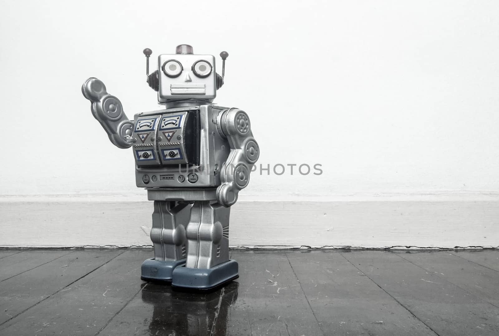 retro silver robot waving hi on an old wooden  by davincidig