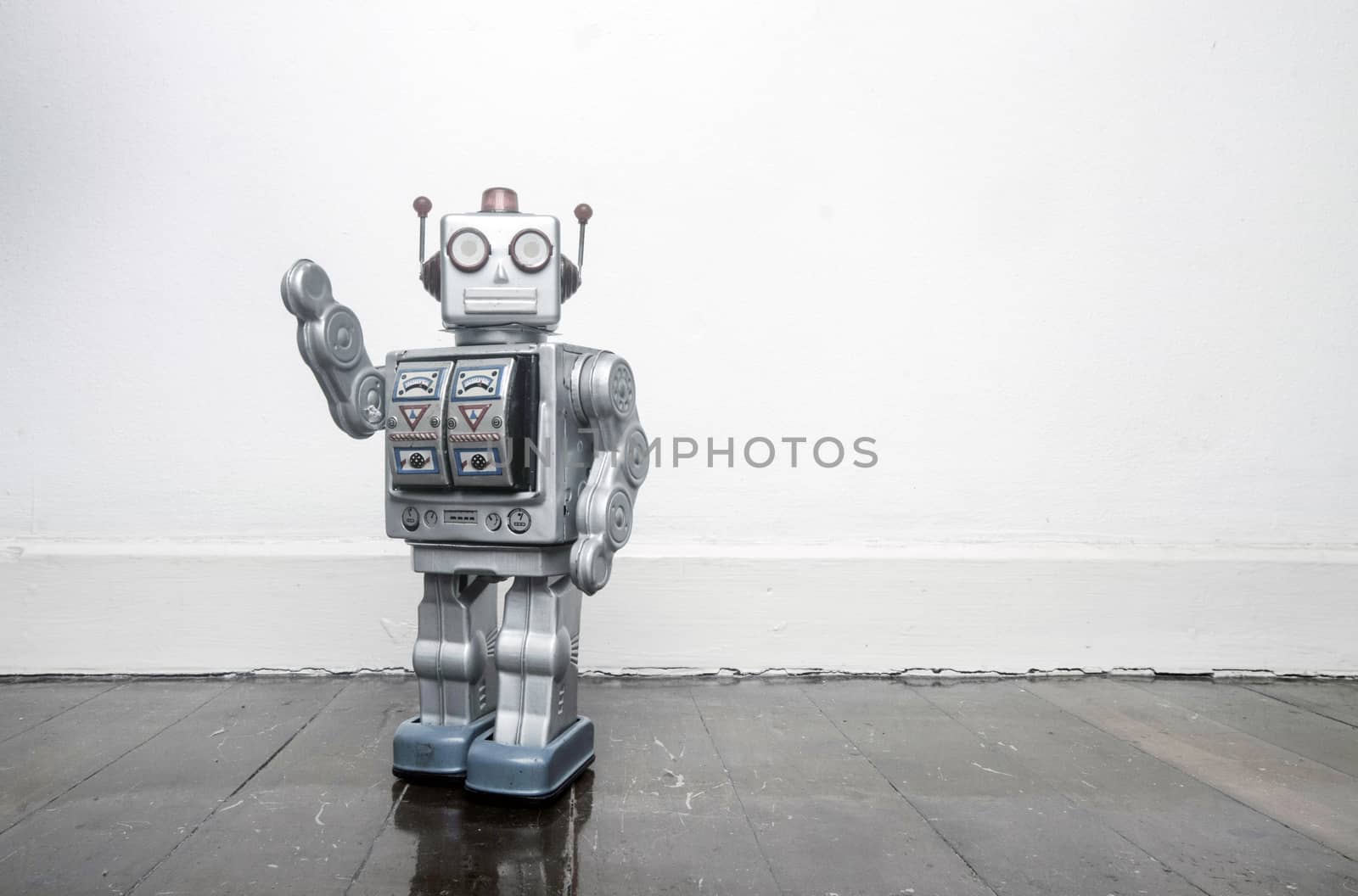 retro silver robot waving hi on an old wooden  by davincidig