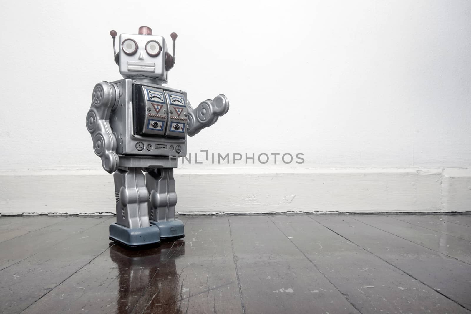 retro silver robot waving hi on an old wooden floor 