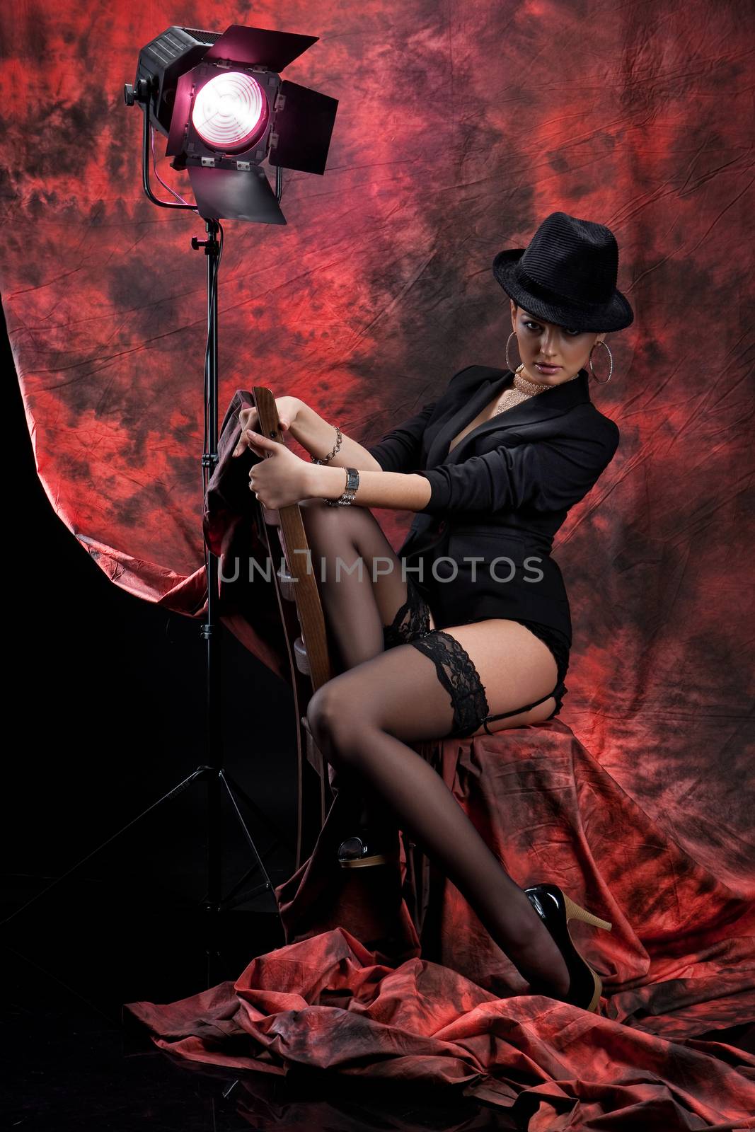 Young beautiful woman in a black clothing on a red and black studio background