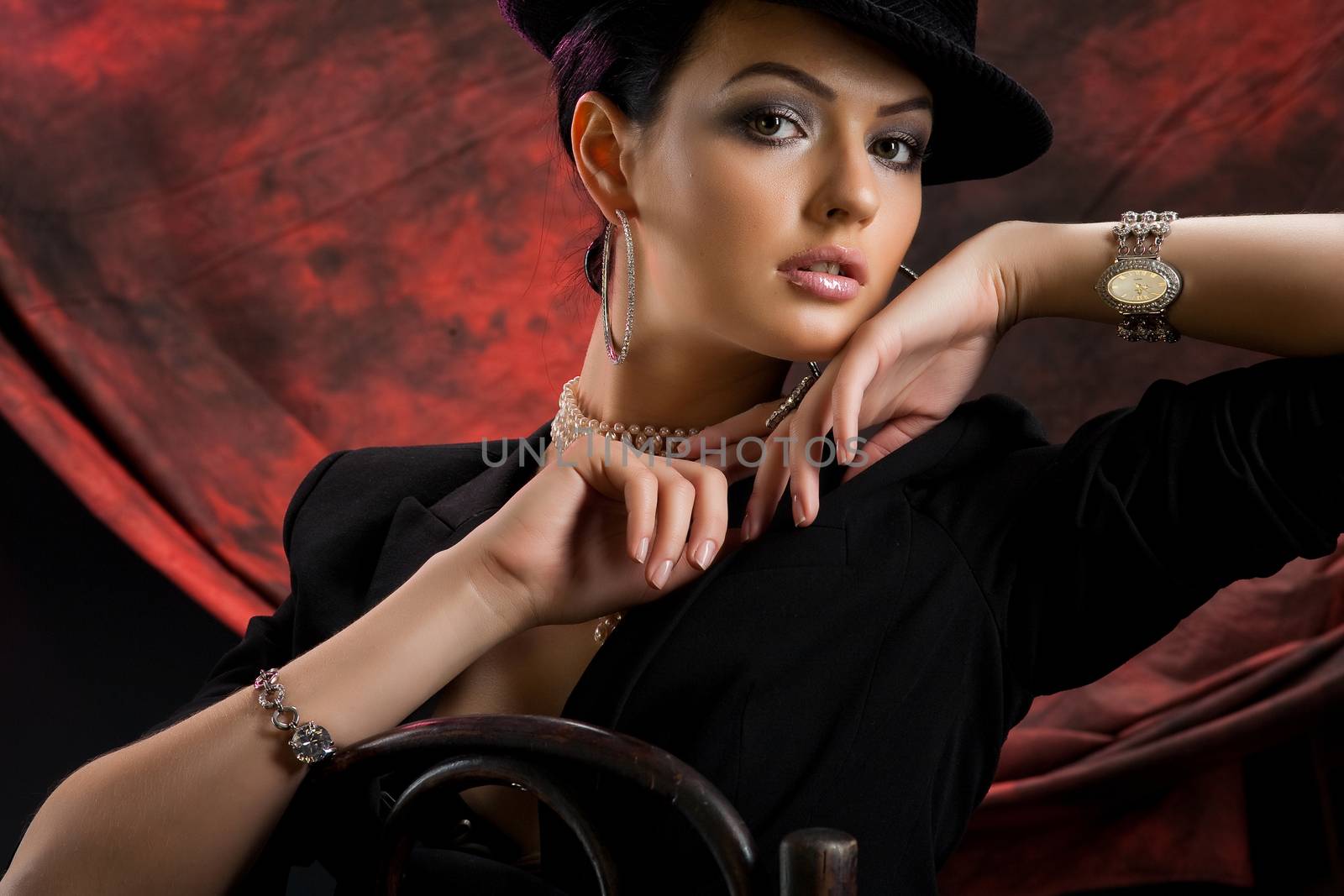 Young beautiful woman in a black clothing on a red and black studio background
