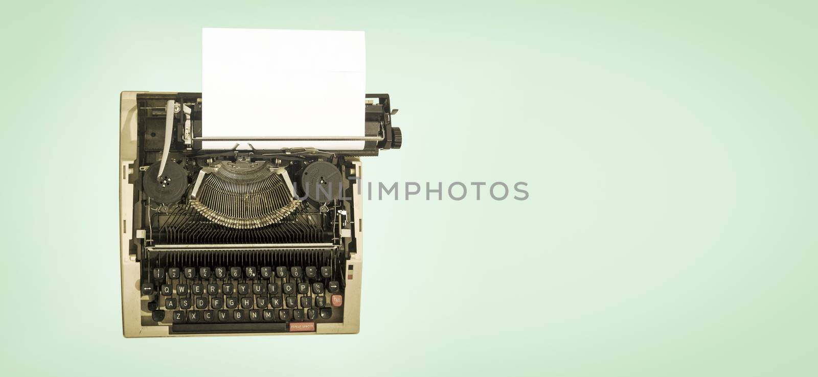 vintage mechanical  typewriter, on a light green background from avove