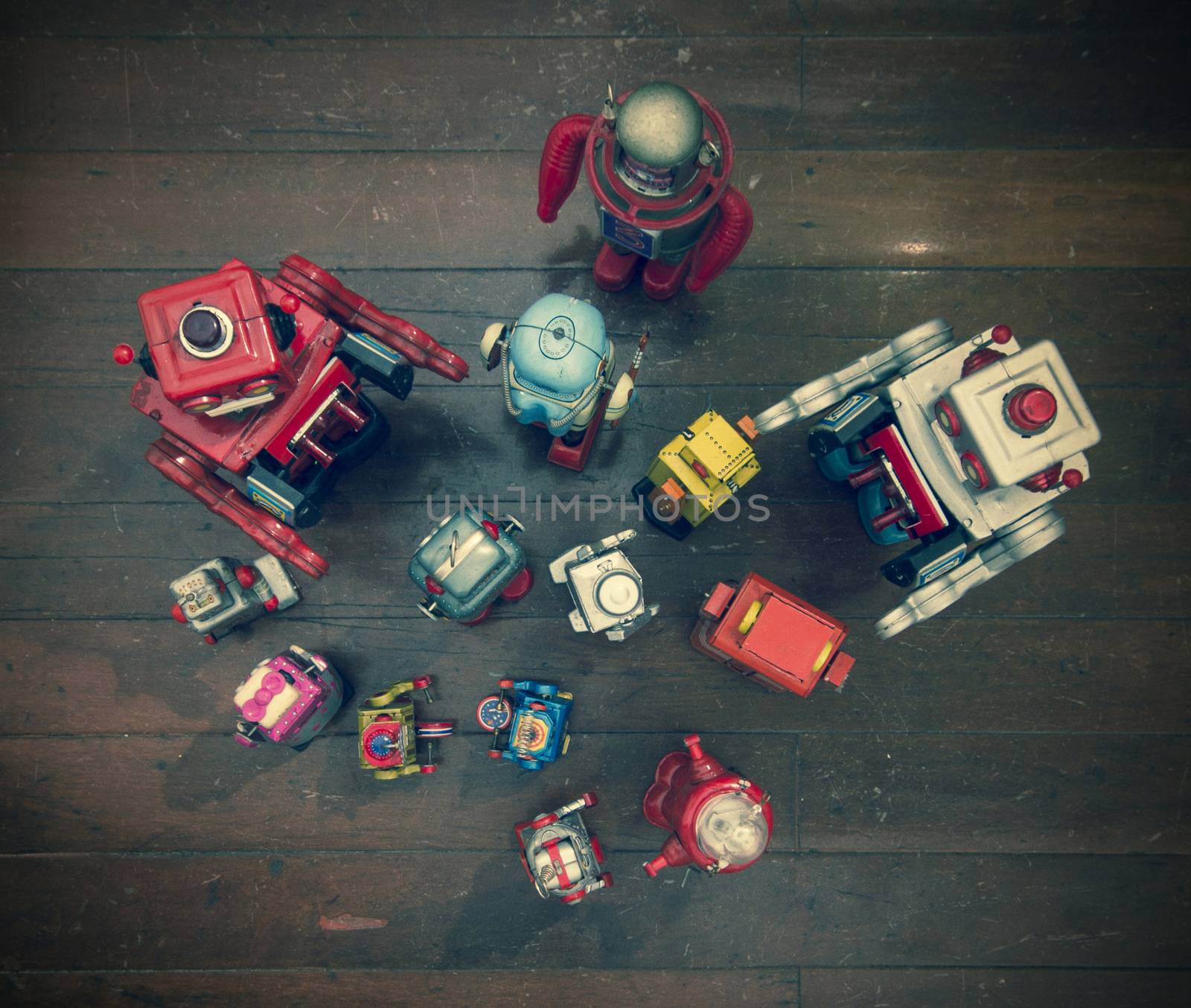 a large group of retro robots gather for a meeting on a old wooden floor