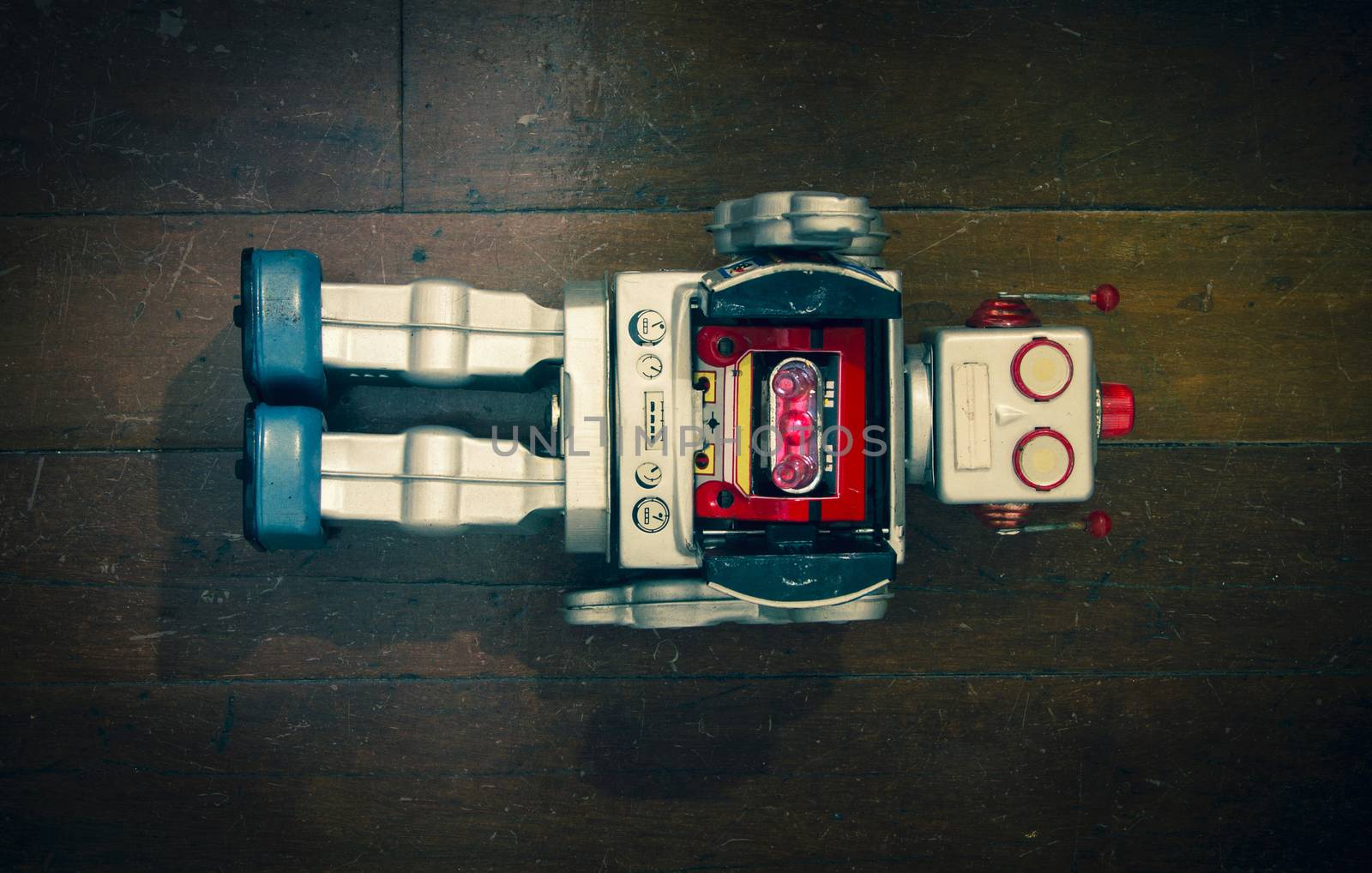 retro silver robot toy lying on  a old wooden floor 