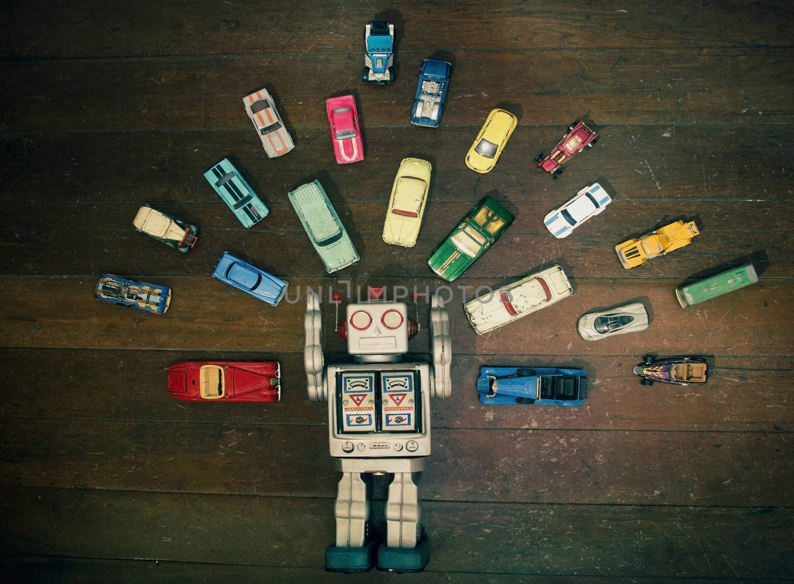 vintage robot toy surounded by lots of retro metal toy cars