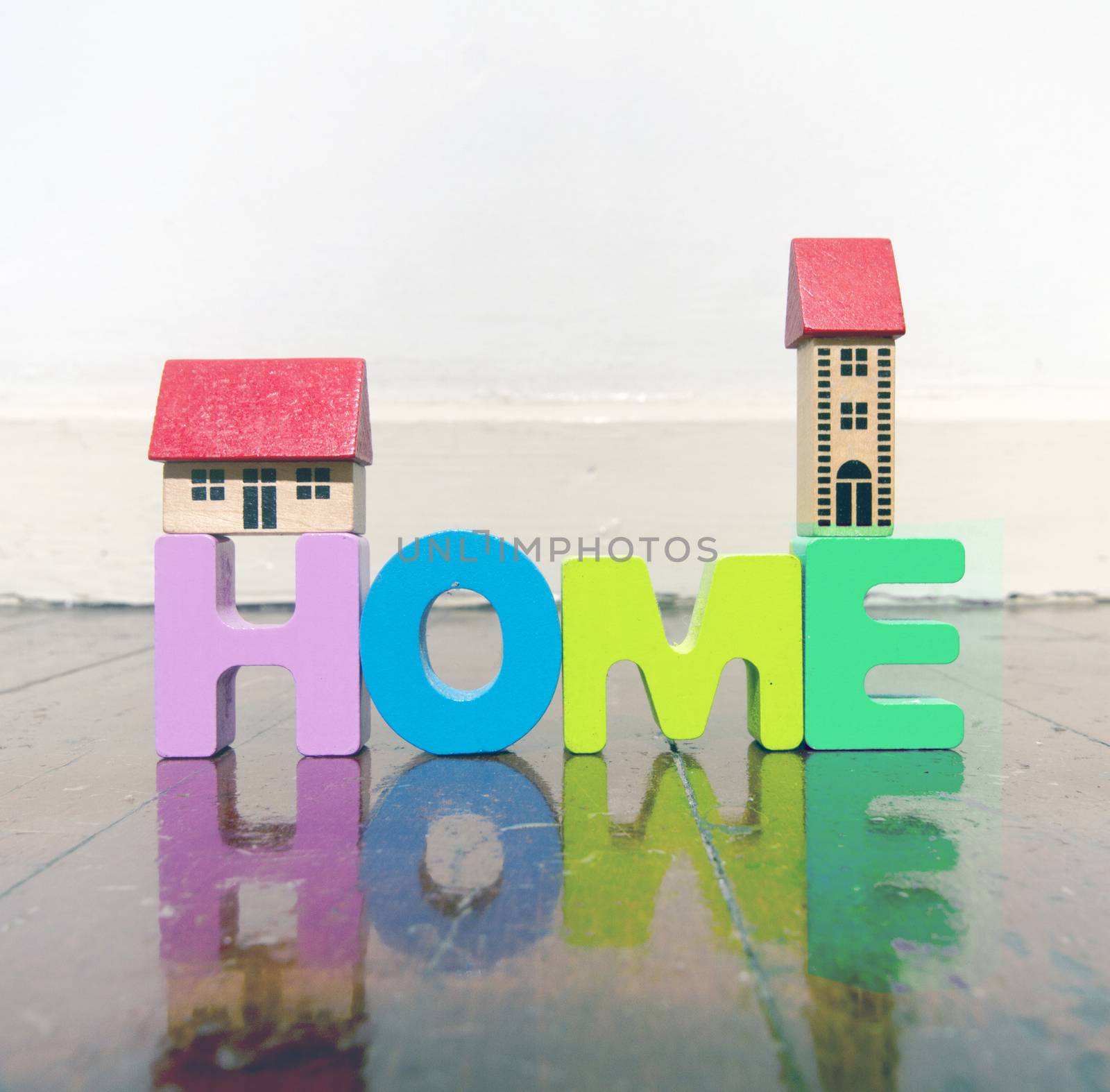 the word home with wooden letters on a wooden floor  by davincidig