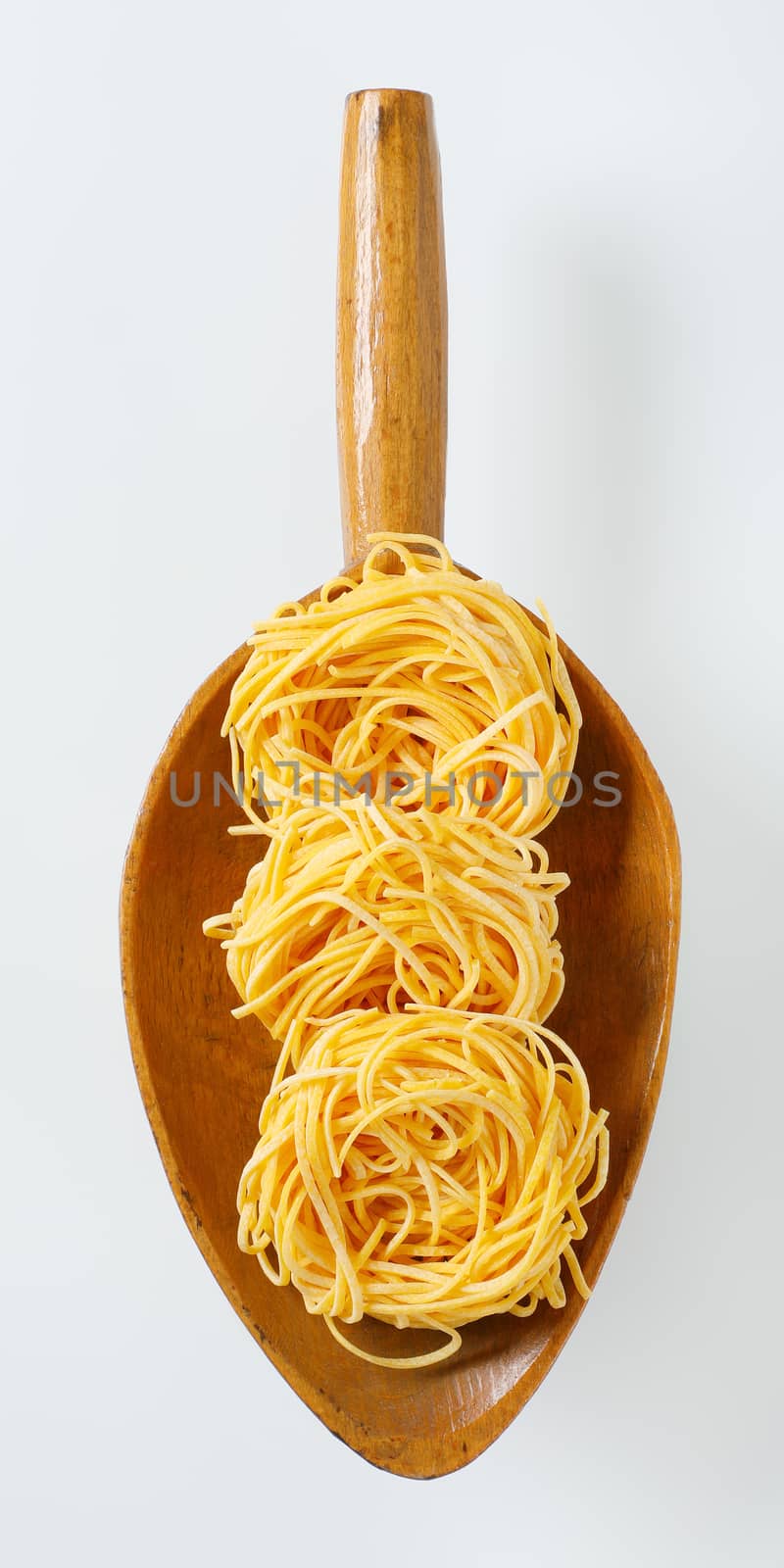 bundles of spaghetti pasta in wooden scoop