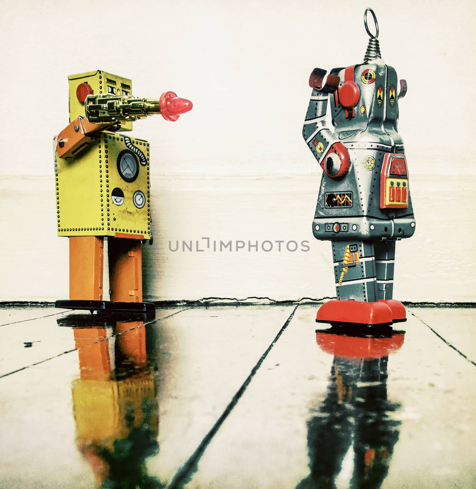 concept gun crime with retro toy robots on a wooden floor 