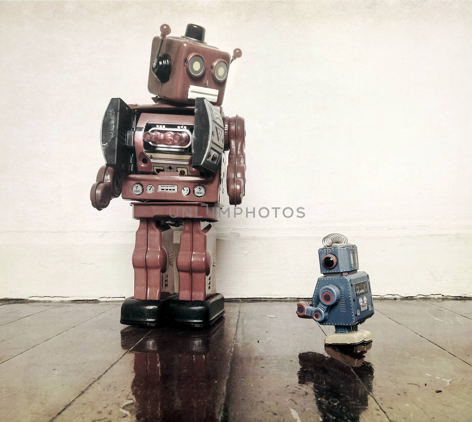 Boss robots looking down on his working robot  on wooden floor with reflection