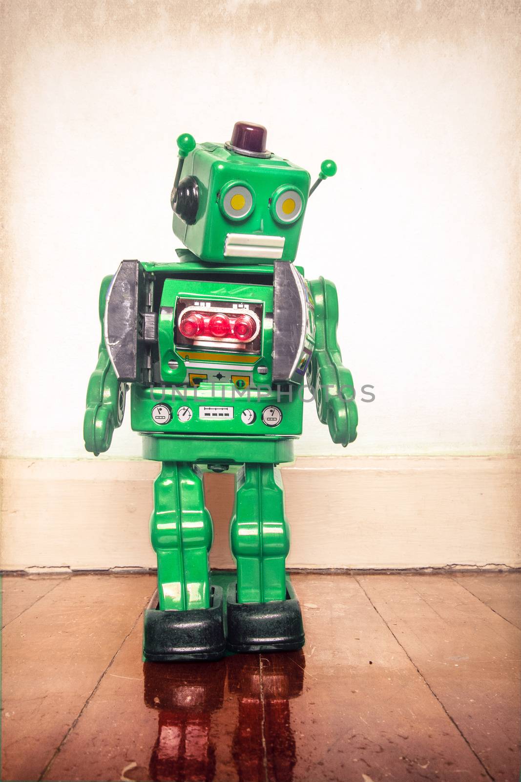 vintage green  retro robot looking down on a old wooden floor with reflection