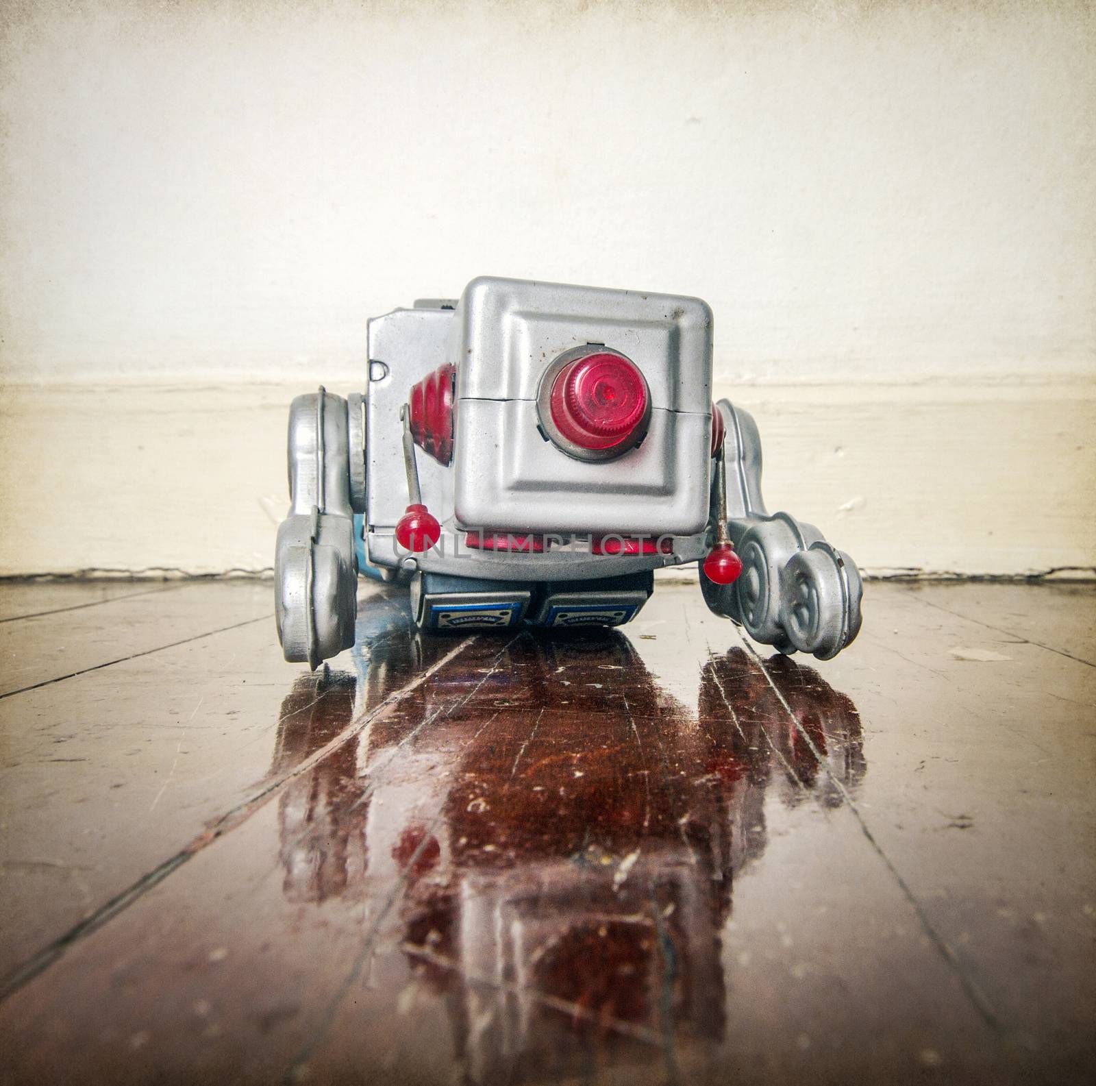 over worked retro silver robot facedown on old wooden floor with reflection