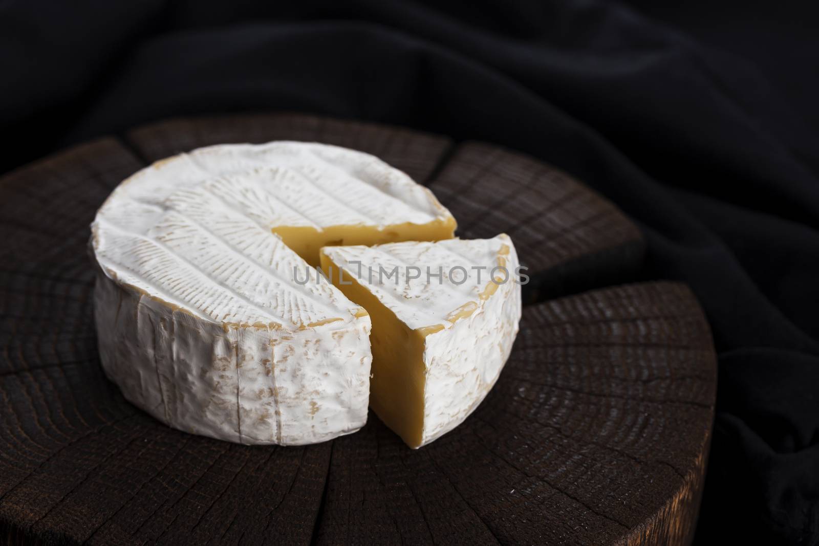 Camembert cheese on black wooden background, with copy space. Shallow depth of field by xamtiw
