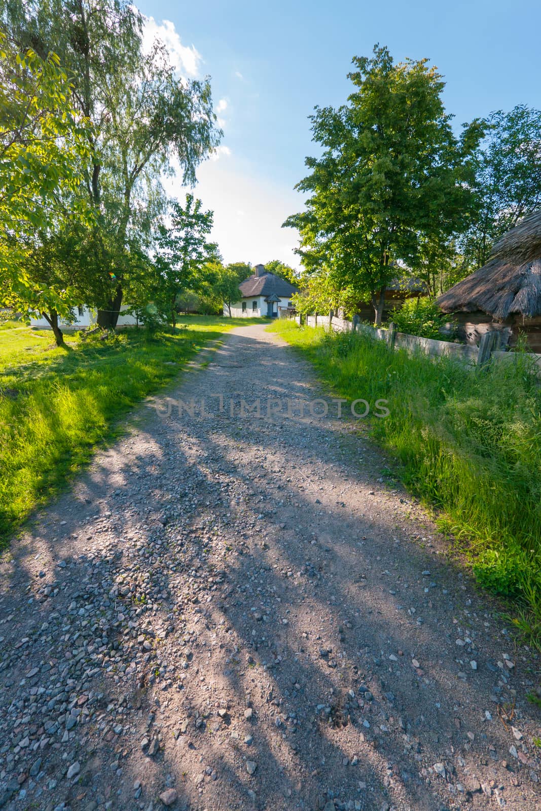 a path on the street of old rural houses with reed roofs. architectural memo