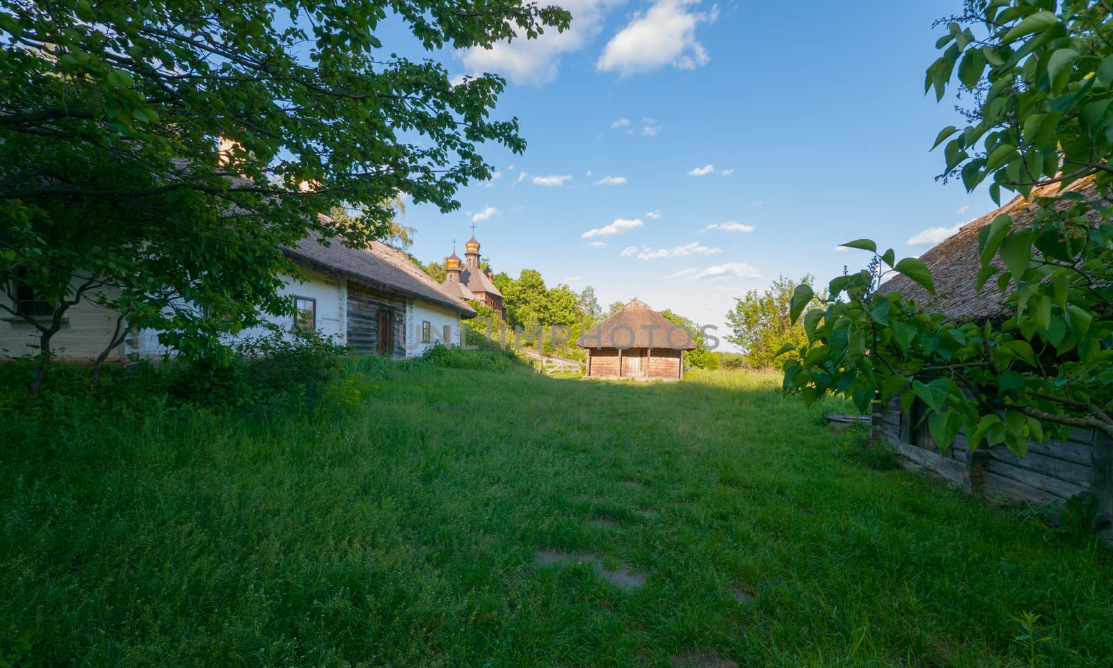 a long wooden house with stables on the overgrown grass of the yard. Uzhhorod Ukraine