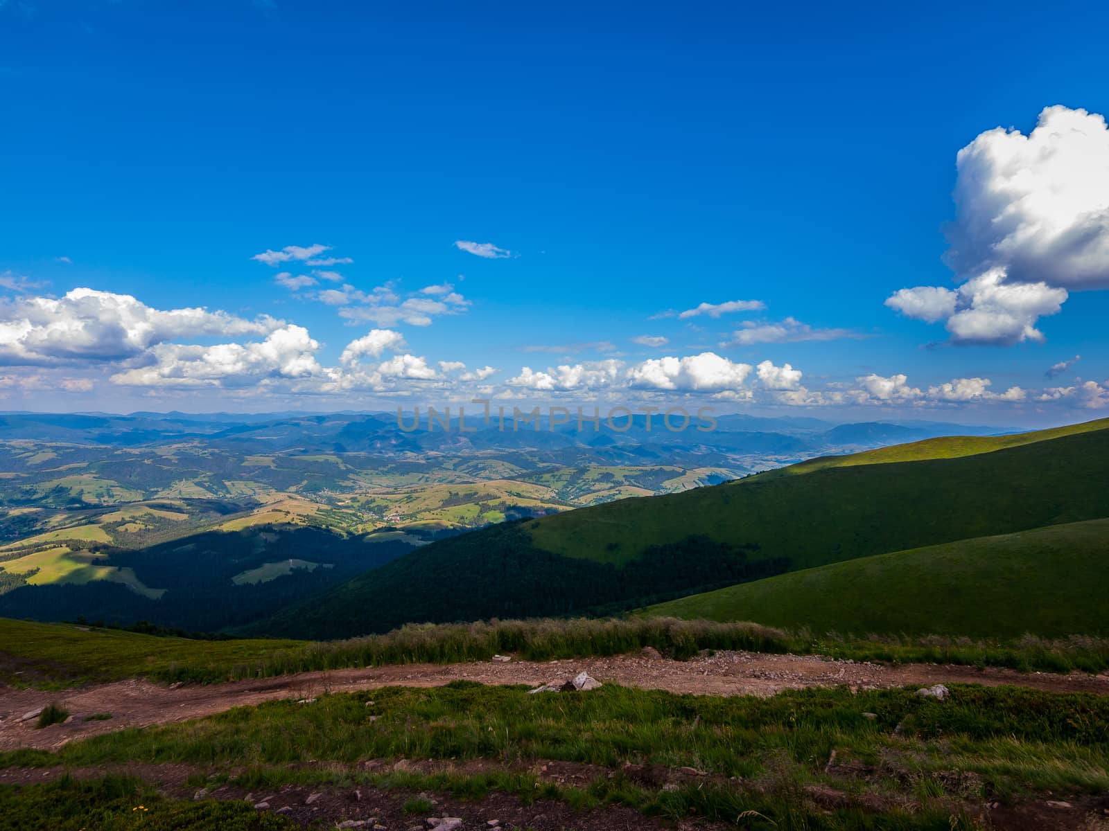Scenic view from a height to the nearby wide mountain ranges and the blue sky
