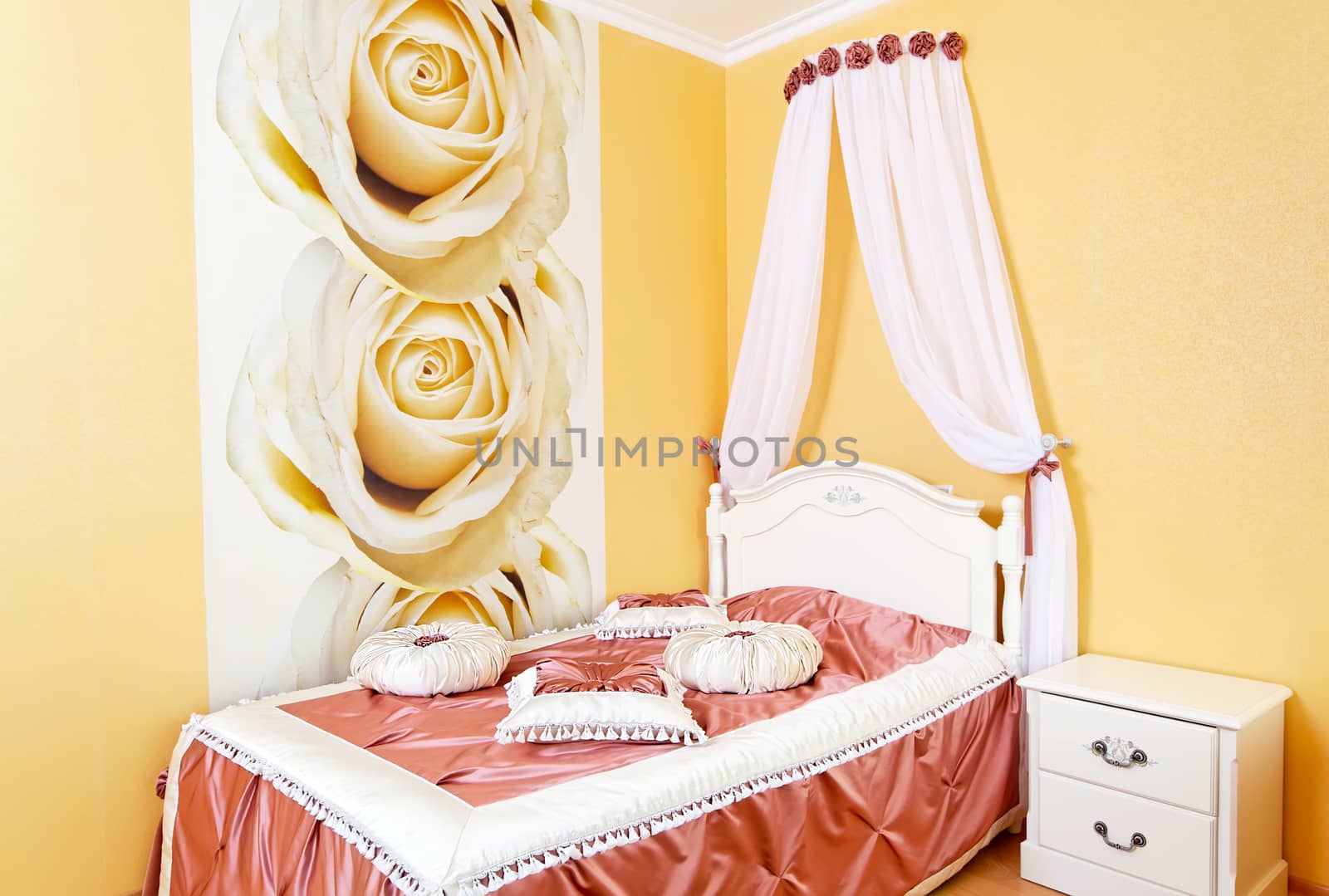 Beautiful bedroom yellow interior with roses and fabric pillows