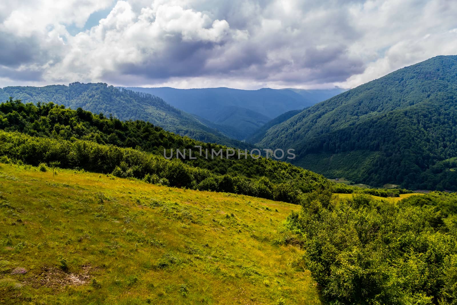 The mountain ridge is covered with fires under the thick clouds in the Carpathians by Adamchuk