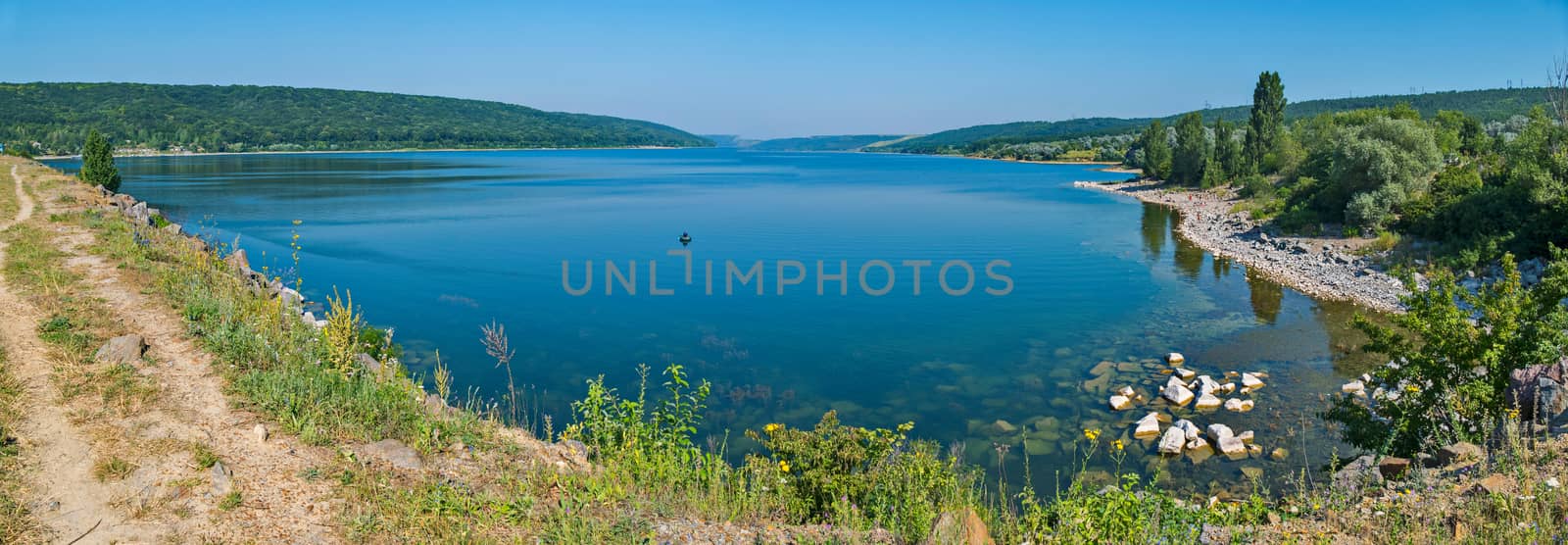 A beautiful panorama of the lake with a clear blue water located in a mountainous area. by Adamchuk