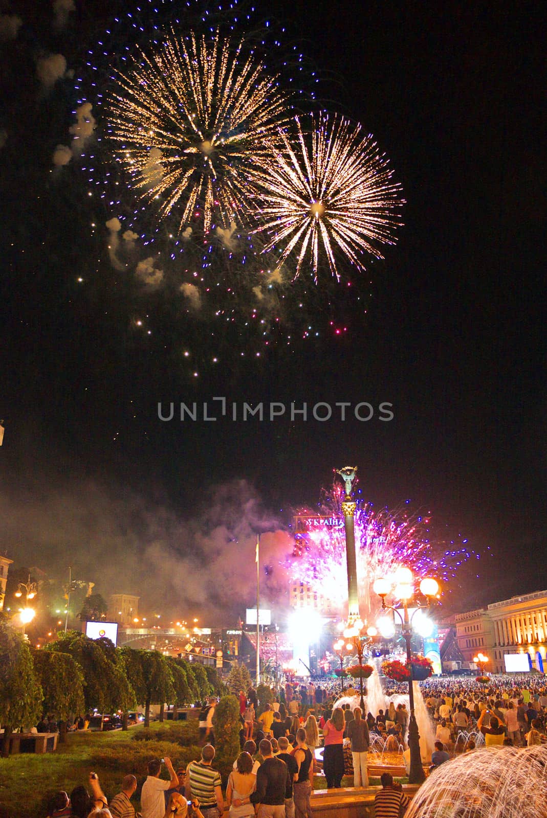 city evening with people celebrating the holiday under the flashes of a colorful salute