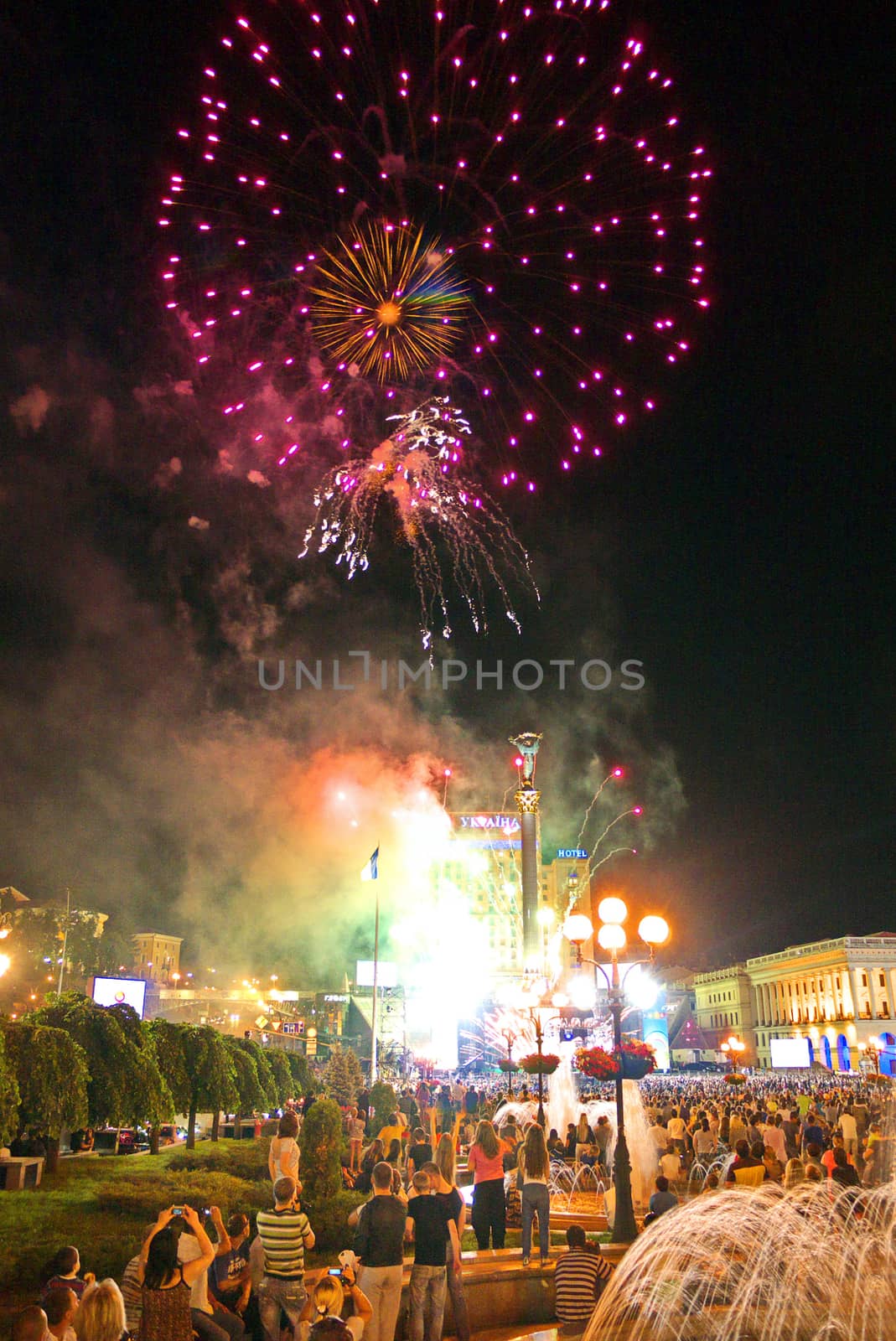 bright flashes of beautiful fireworks in the city against the background of a large number of people